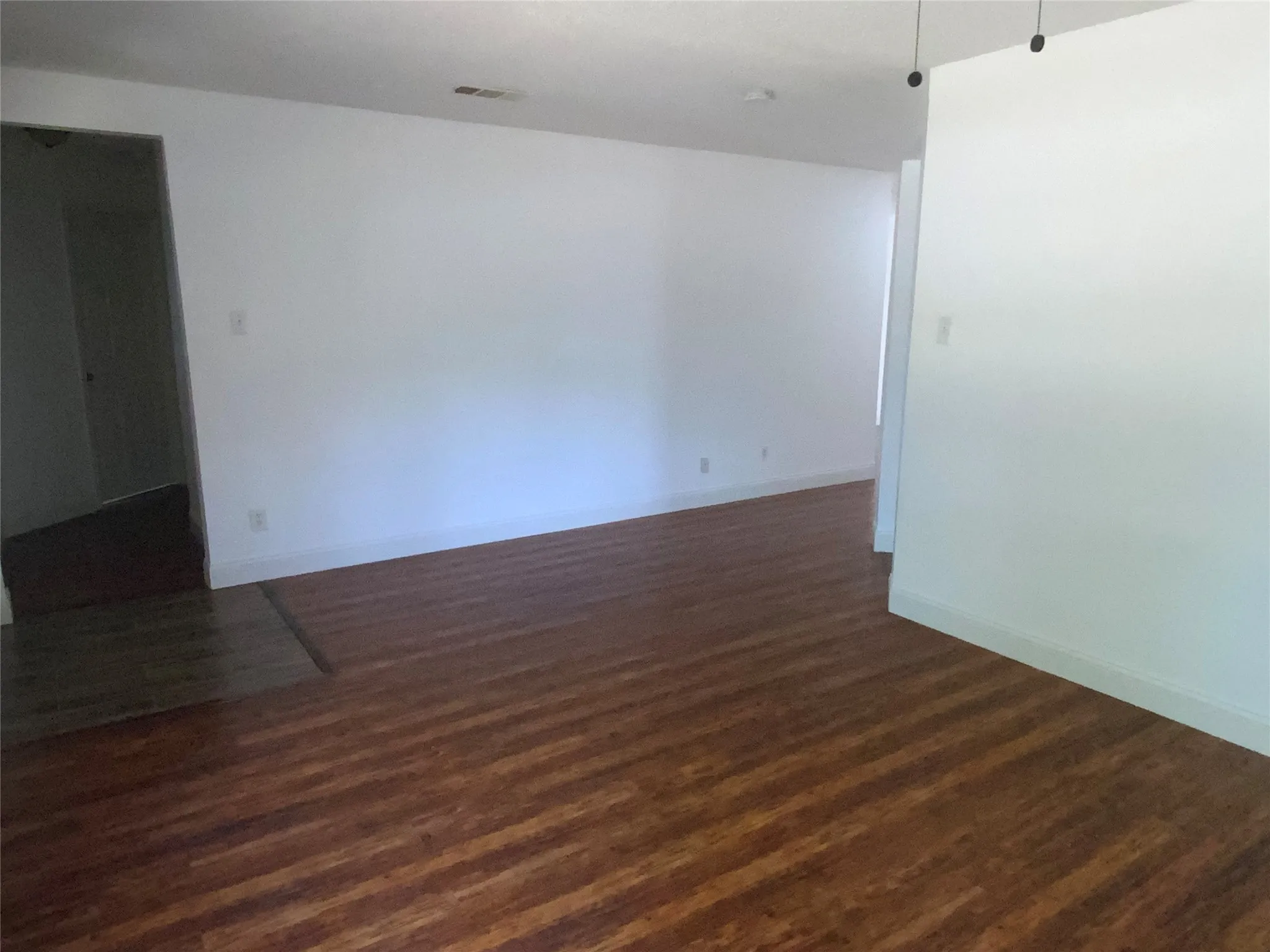 Expansive interior with wood-finish flooring and white walls
