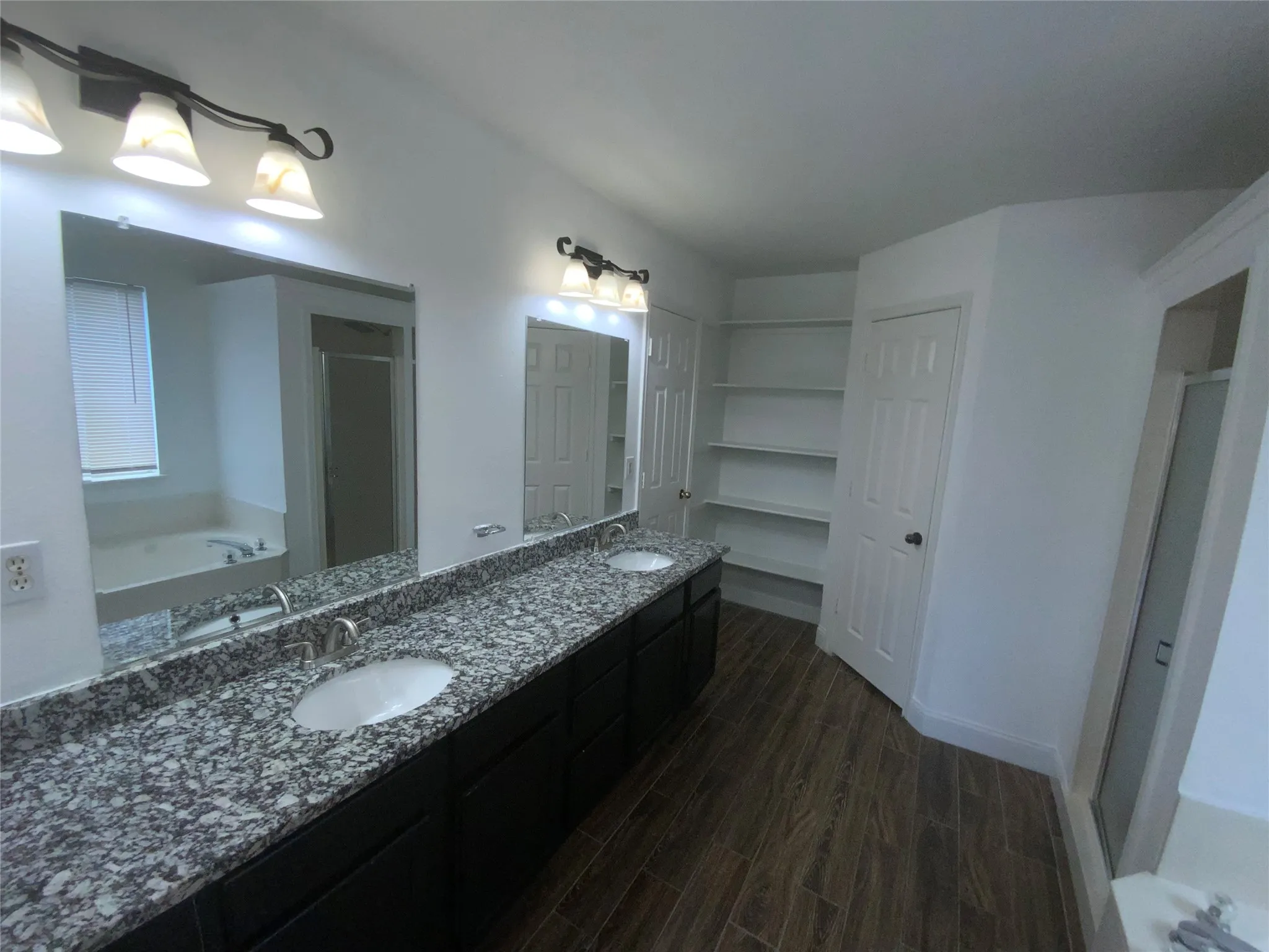 Dual vanity with granite countertops, undermount sinks, and brushed nickel fixtures
