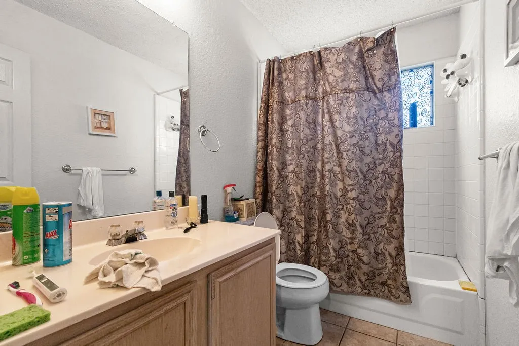 Vanity with integrated sink, full-width mirror, and a built-in bathtub with white tile surround