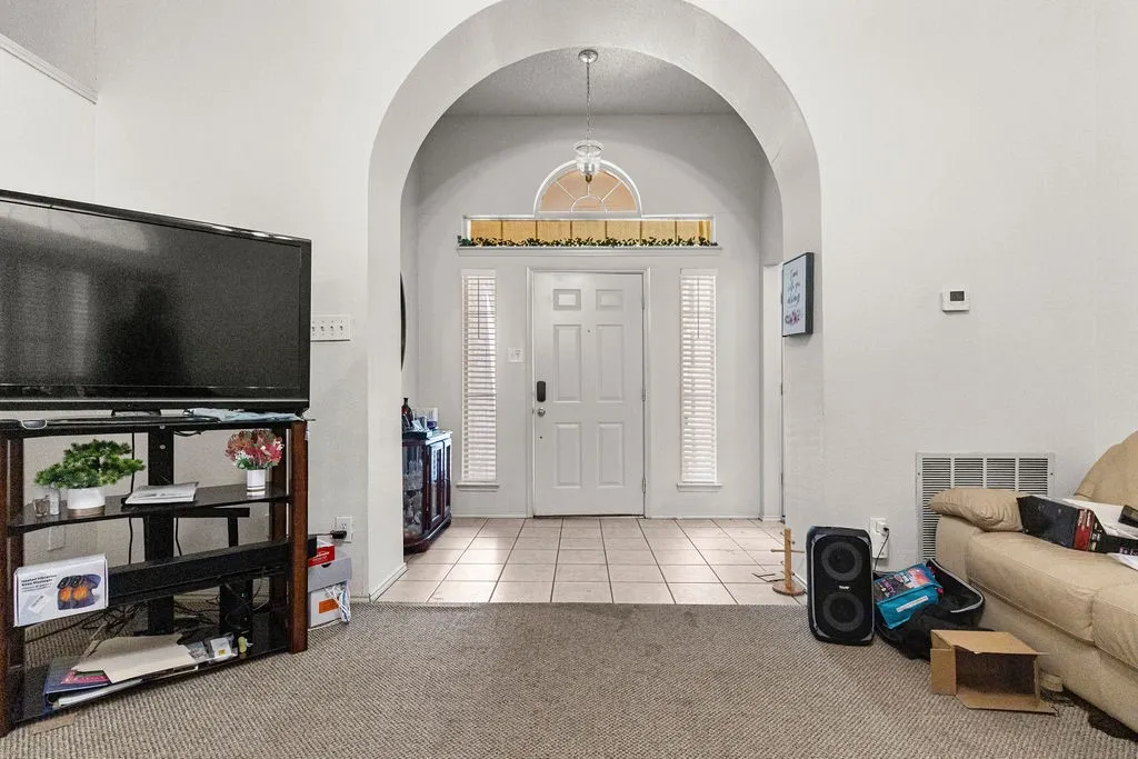 Archway entry with a front door featuring side-light windows and an arched transom