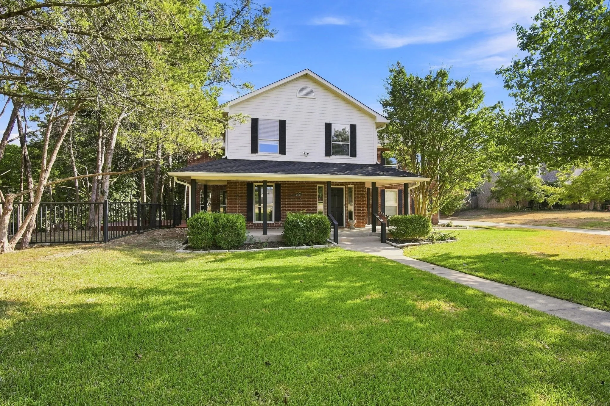 A striking two-story exterior with brick and siding, a columned front porch, and a classic gabled roofline welcomes you home.