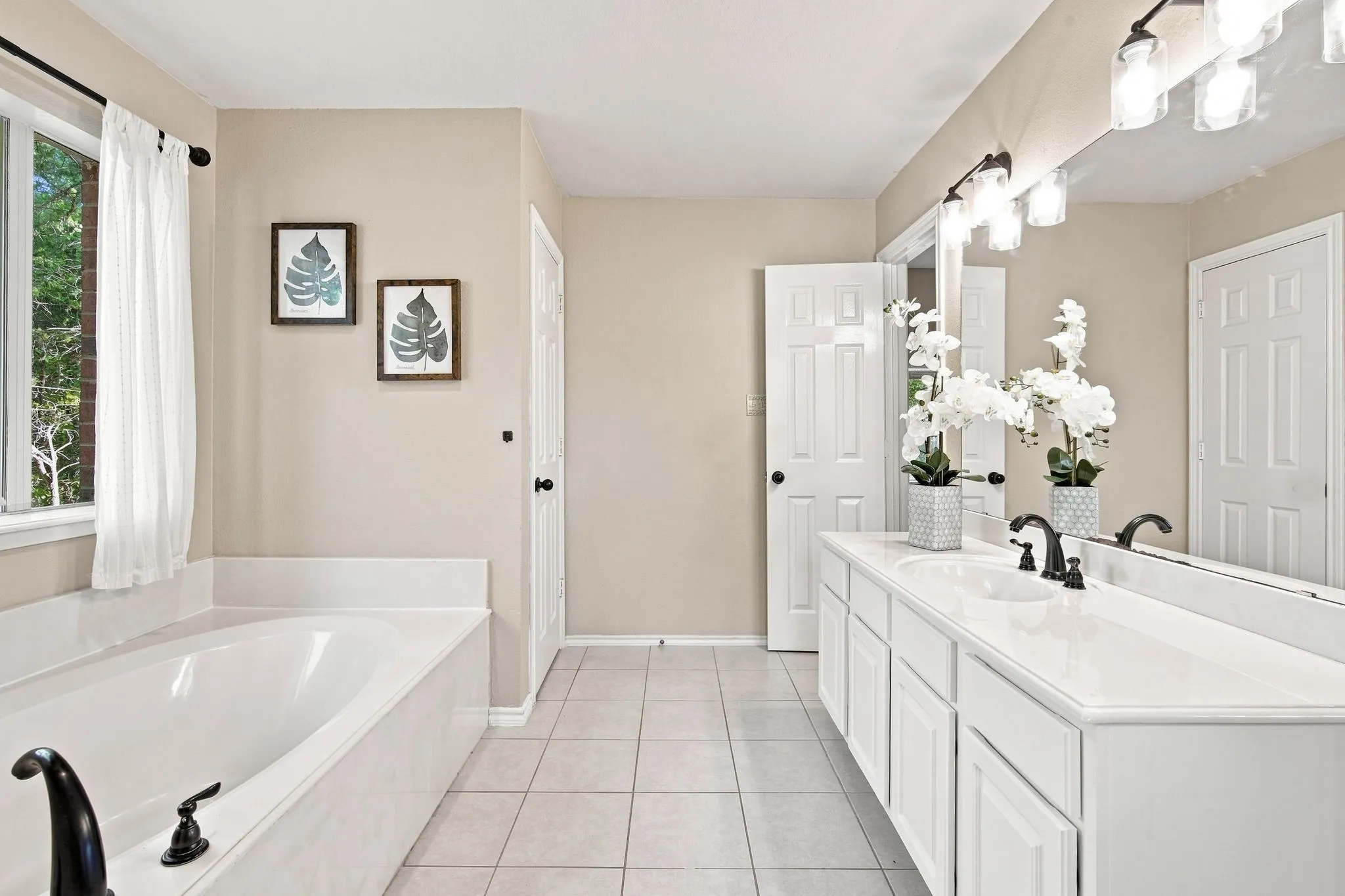 Elegant vanity with undermount sink, matte black faucets, and a large mirror for a spa-like feel.