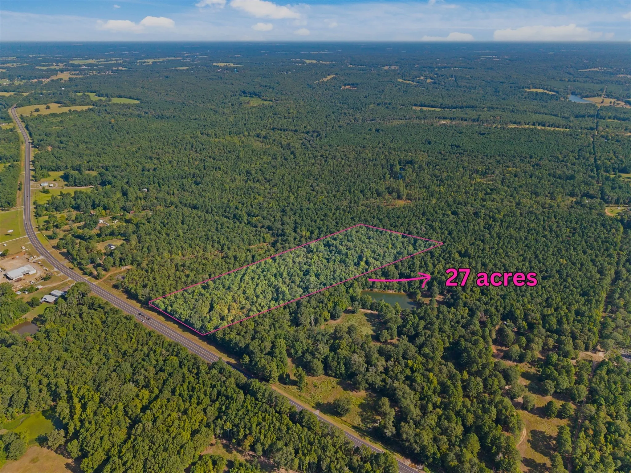 Expansive 27-acre wooded property featuring a private pond and direct road frontage