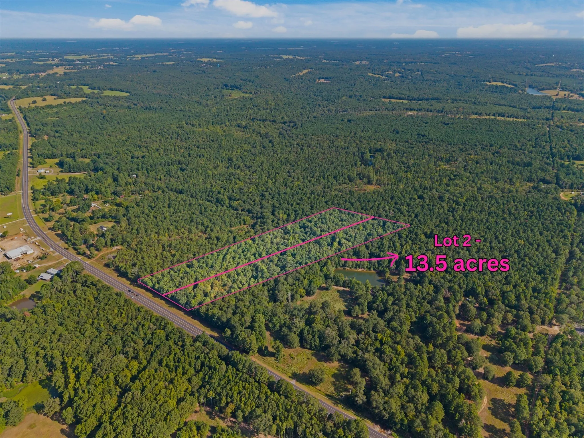 Expansive wooded acreage featuring a visible pond