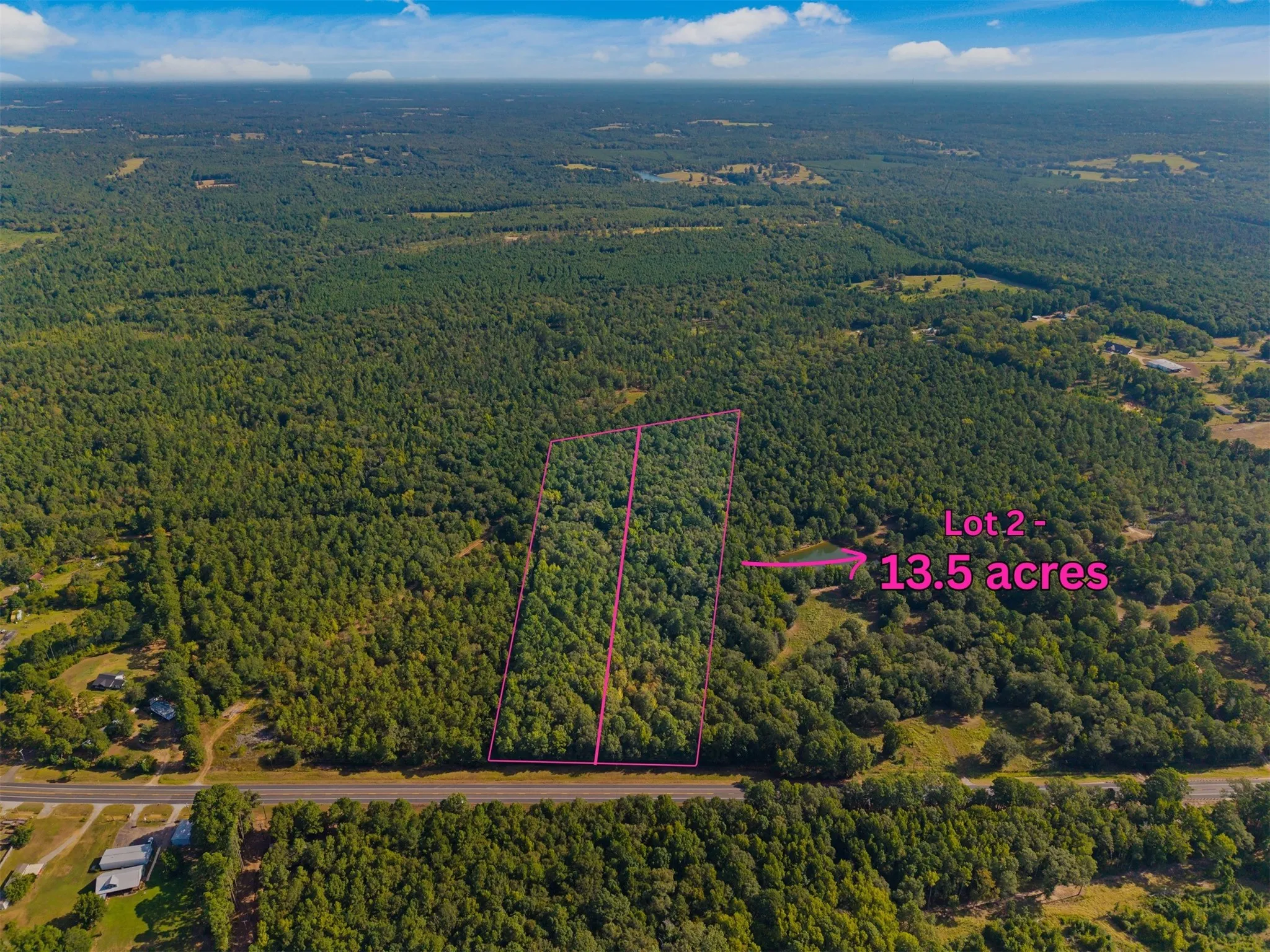 Expansive 13.5-acre lot featuring dense tree coverage and direct road frontage