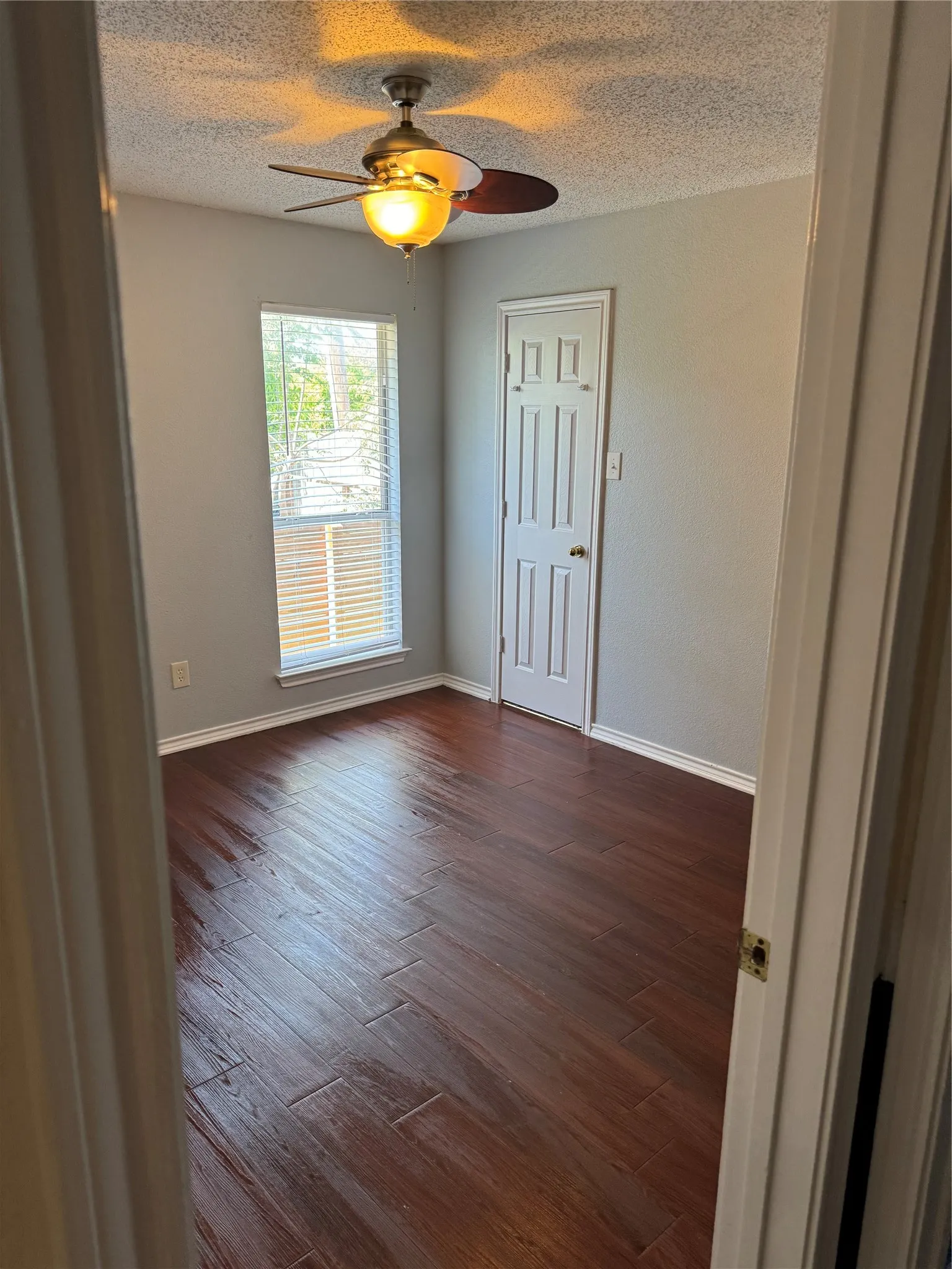 Spare room featuring a textured ceiling, ceiling fan, and dark hardwood / wood-style flooring