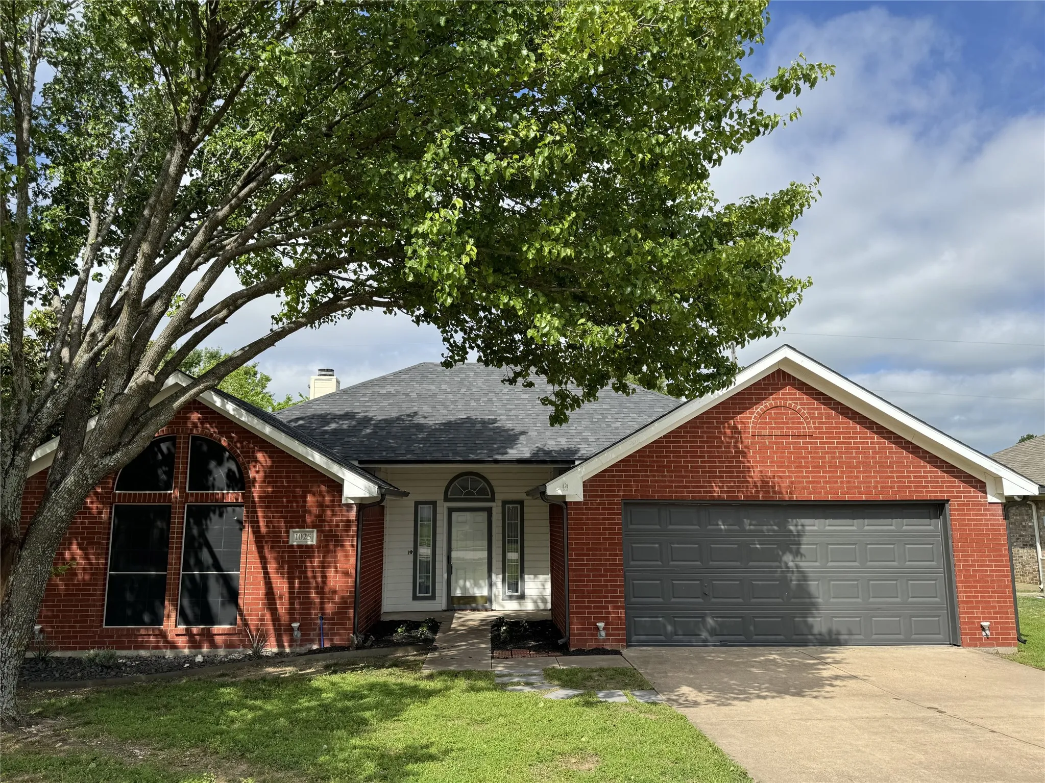 View of front of home featuring a garage and a front yard