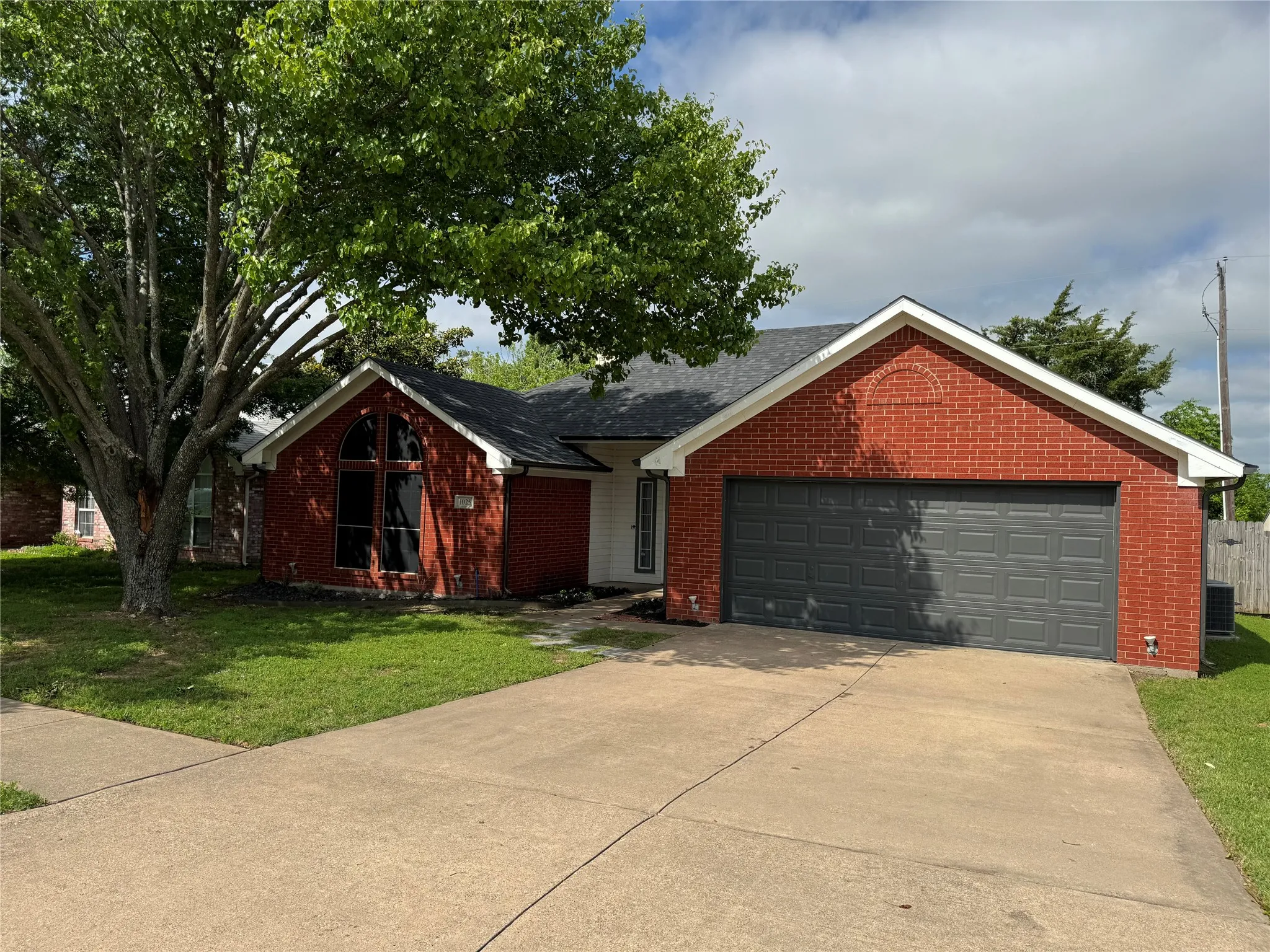 Ranch-style house with central AC and a front yard