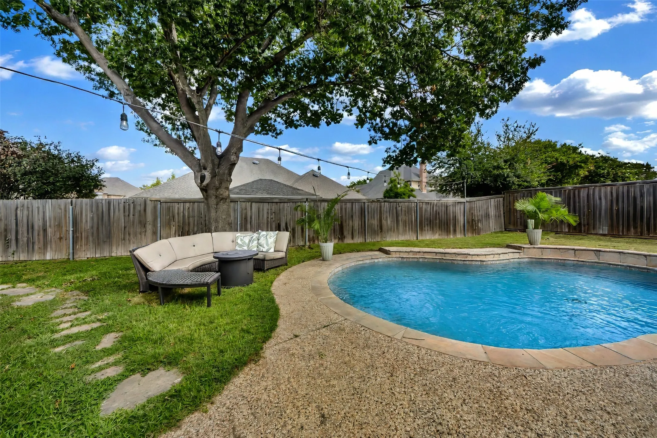Pool, exposed aggregate decking and yard area enhanced by mature tree.