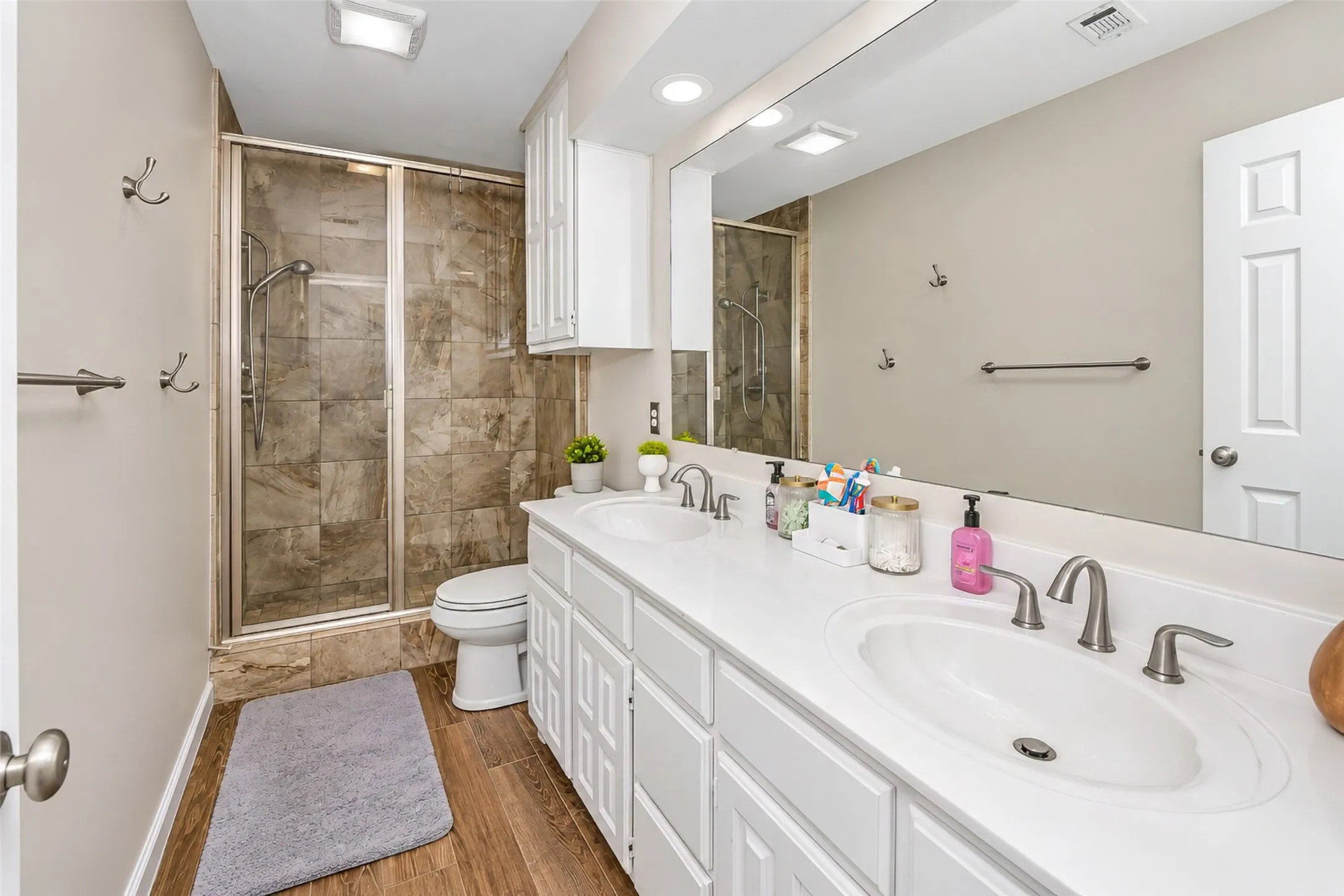 The guest bathroom features an updated walk in shower and dual sinks.