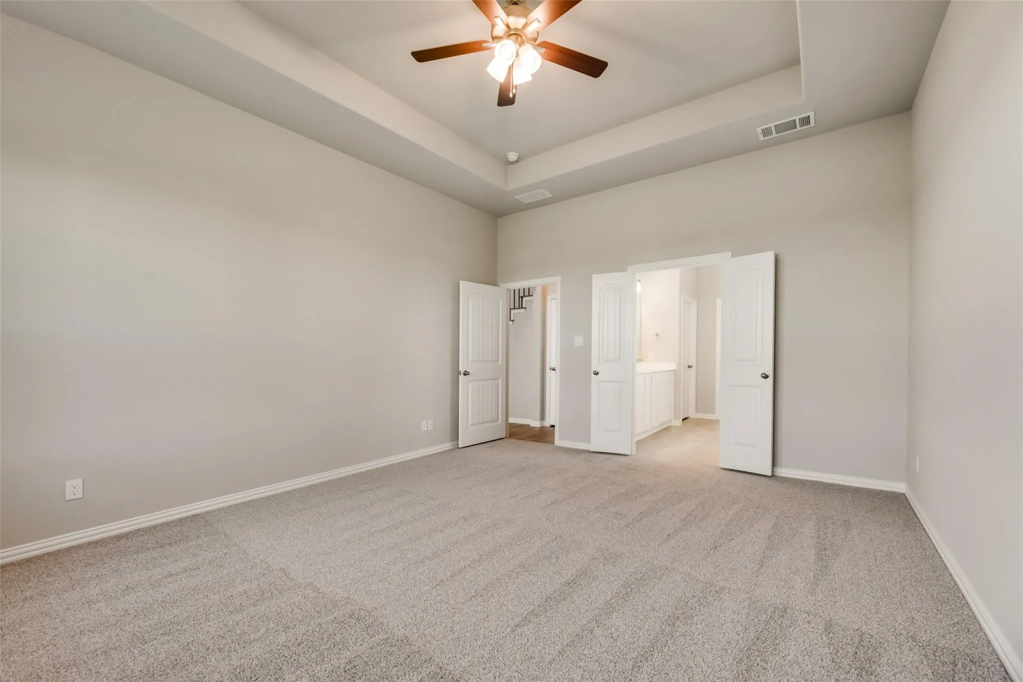 Tray ceiling, ceiling fan, carpet flooring, light neutral wall paint, white trim