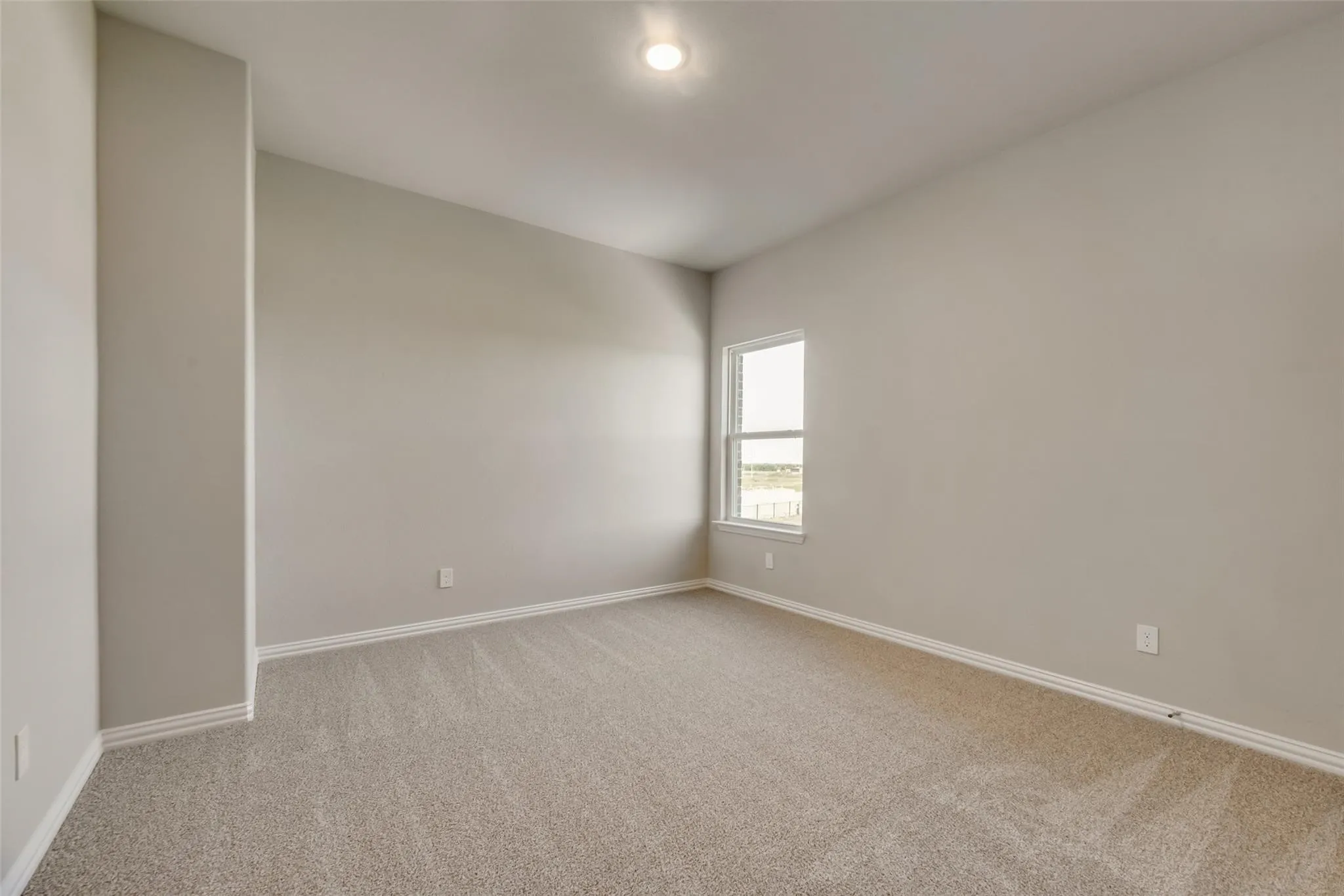 Neutral-toned walls, recessed ceiling light, carpeted flooring, and a single window