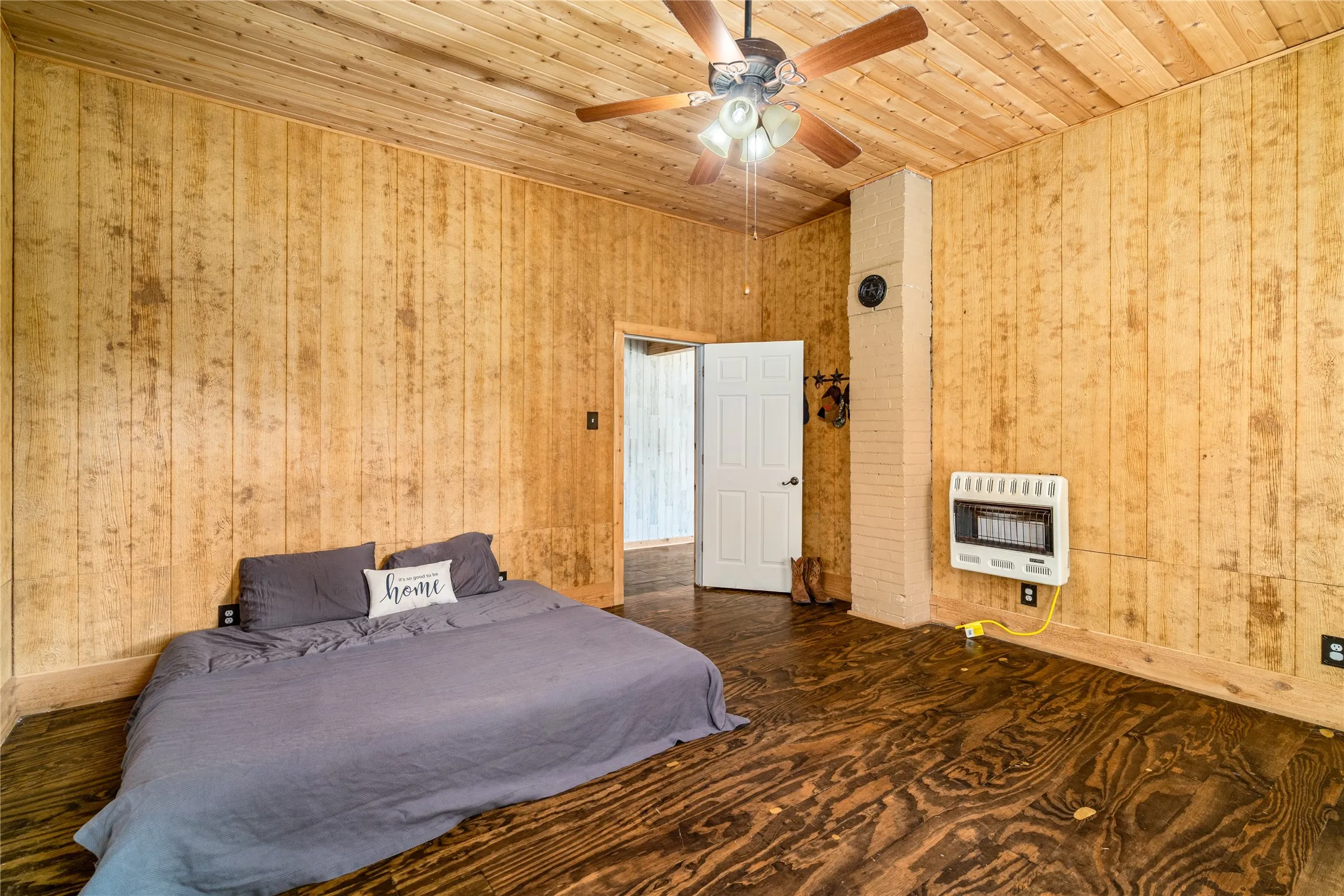 Wood-paneled walls and ceiling with a ceiling fan