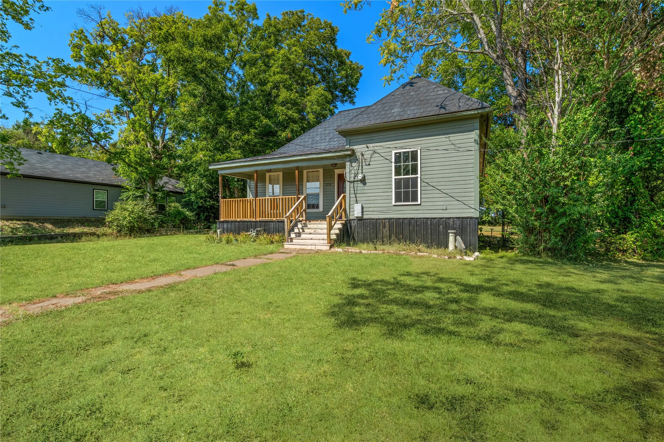 Gray siding exterior with a covered porch and wood railings