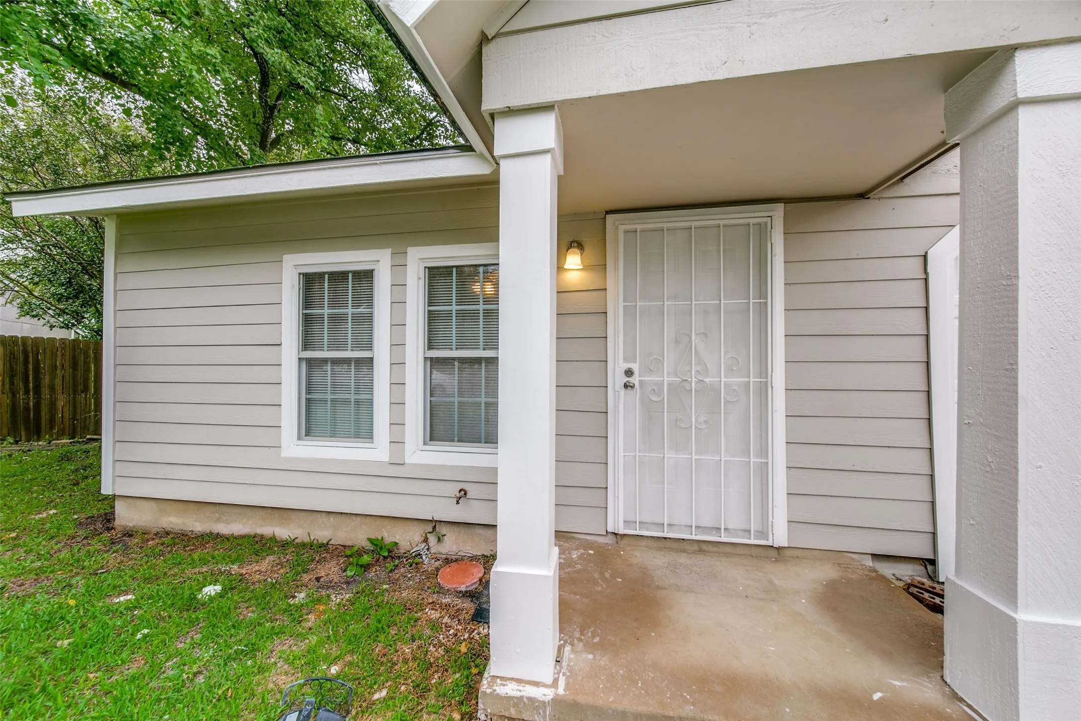 Horizontal siding exterior, covered entry, security screen door, and exterior lighting fixture
