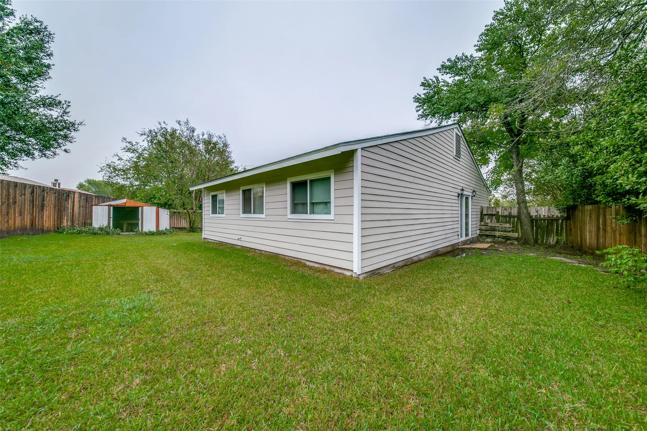 Expansive lawn area with a full privacy fence