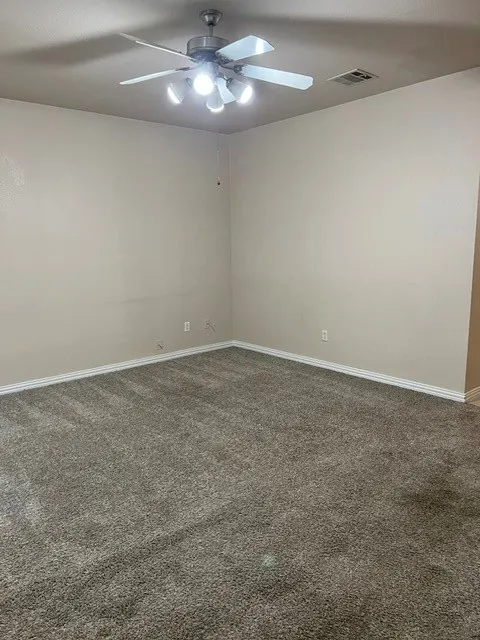 Ceiling fan with integrated lighting, neutral wall tones, and plush carpeting