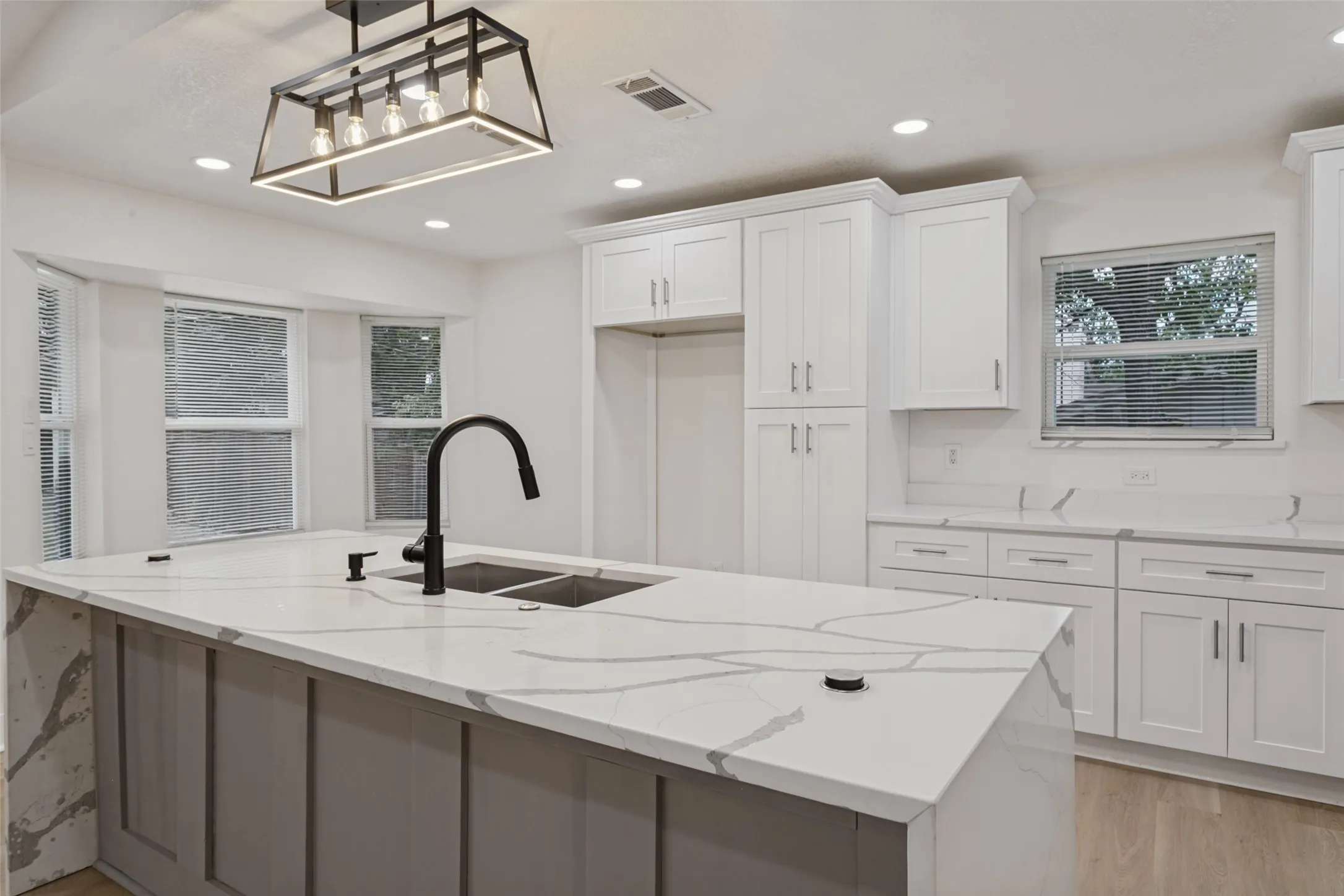 Central island with stone countertop and integrated double sink