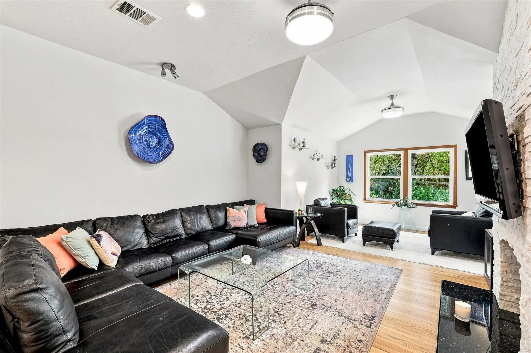 Living room features vaulted ceilings with recessed lighting, updated fireplace with split faced brick and granite hearth.