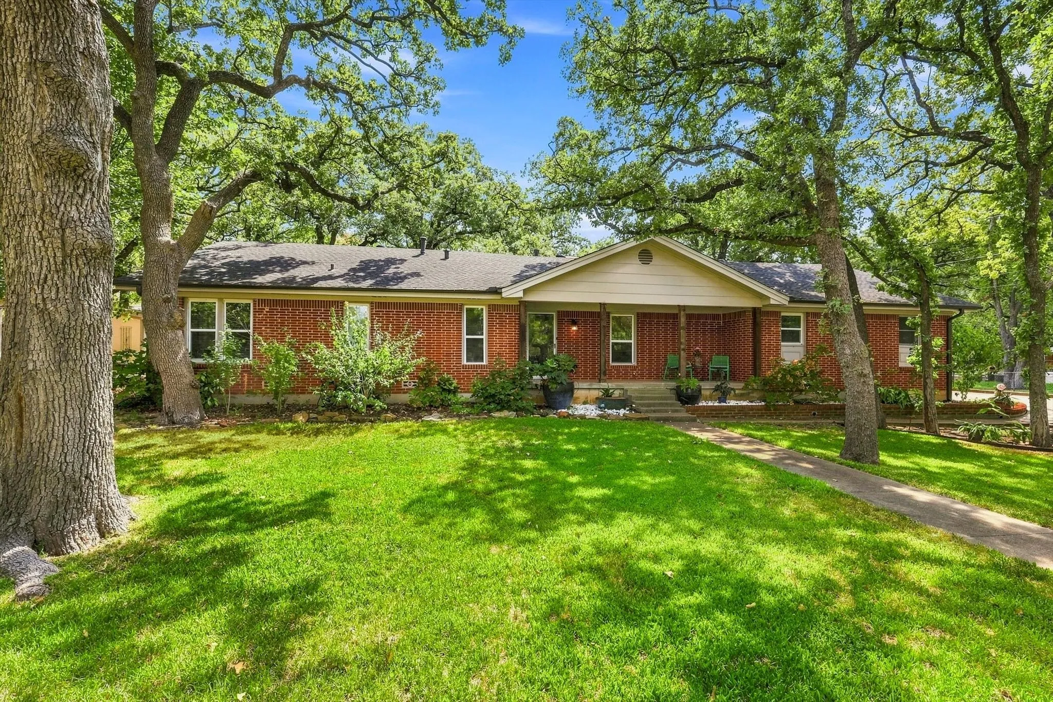 Long porch overlooks lush landscaping - ideal for evening drinks with friends and neighbors.