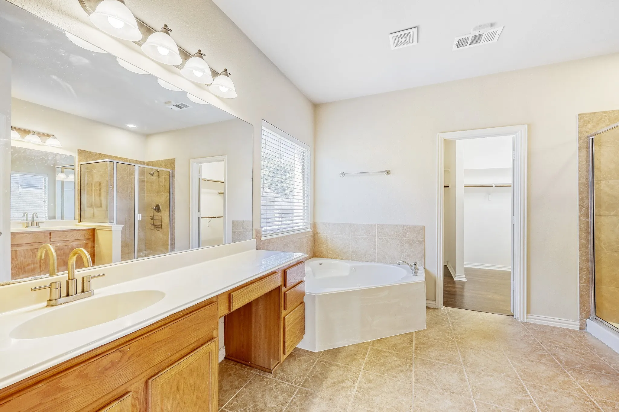 Dual vanity with brass-finish fixtures and an integrated makeup counter
