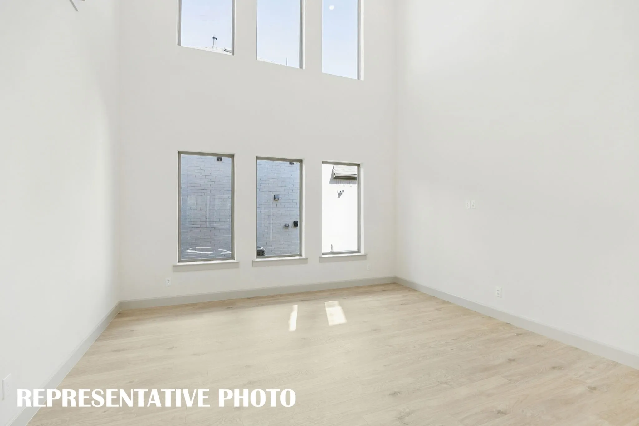 The entire family will love hosting family get togethers in this living room featuring a wall of dual stacked windows!  REPRESENTATIVE PHOTO