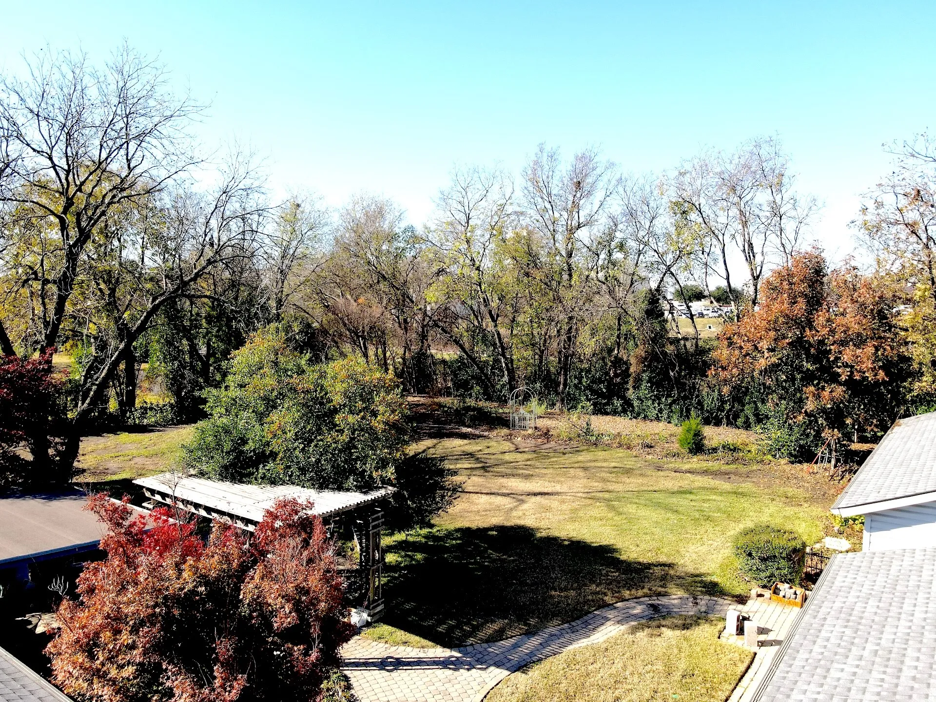 Expansive green space featuring mature trees and a paved walkway