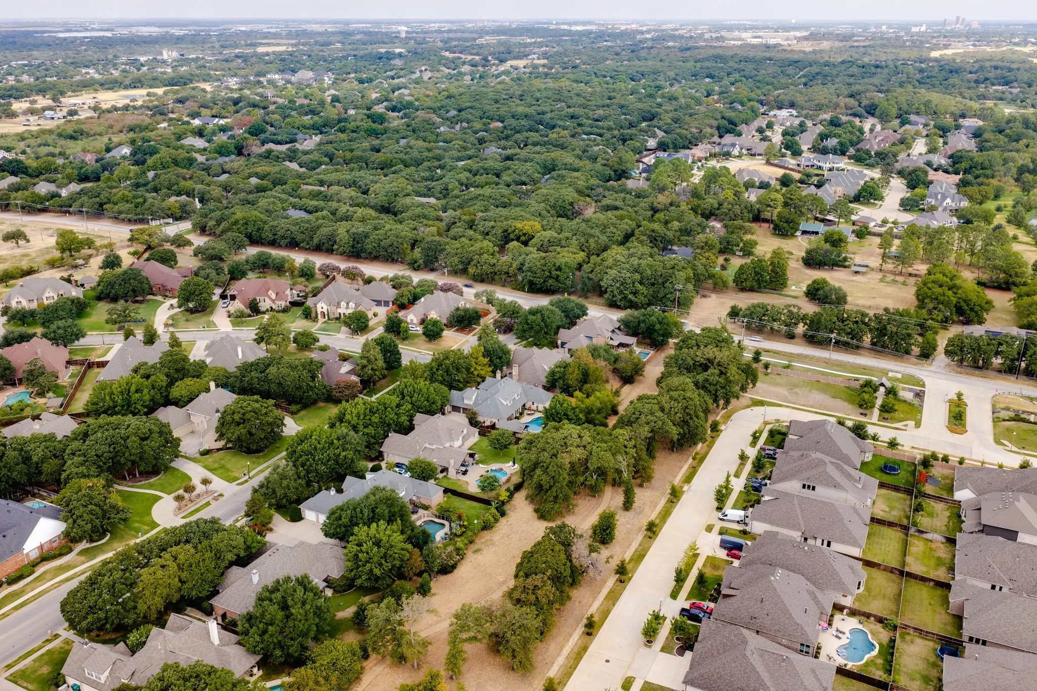 Residential neighborhood with mature trees, established properties, new construction homes, and a structured street layout