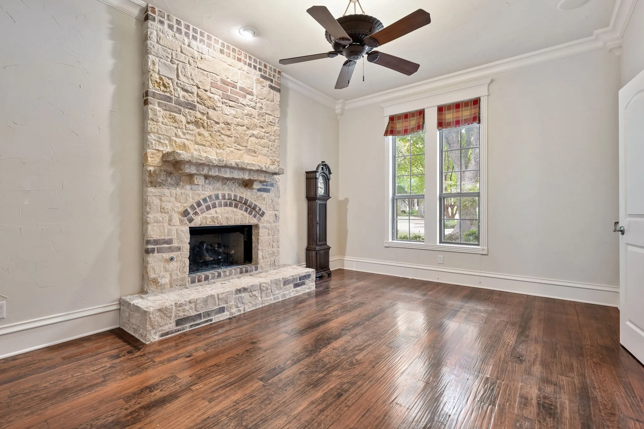 Floor-to-ceiling stone fireplace with an arched firebox and hearth