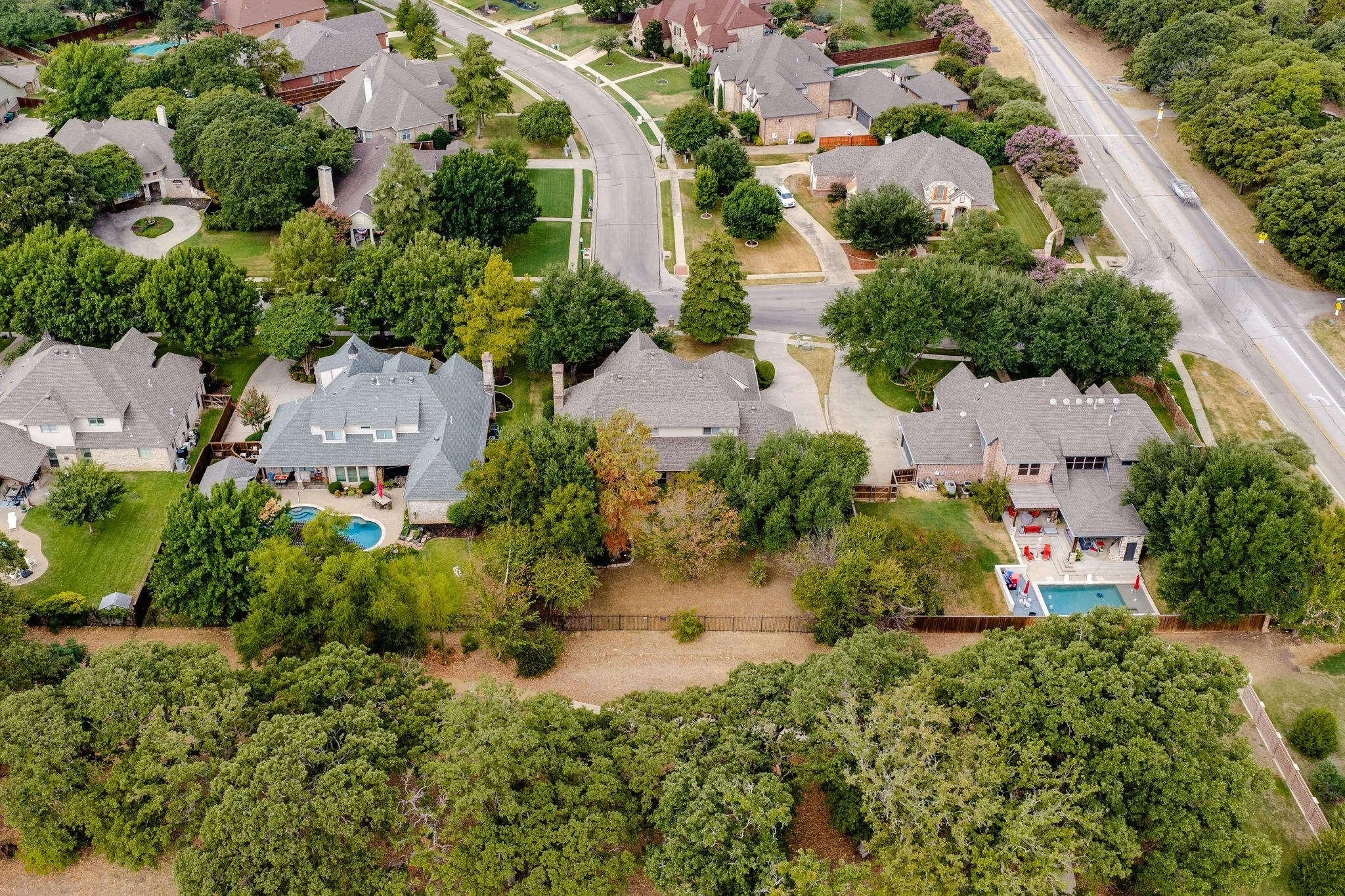 Aerial perspective of a residential street with homes featuring pitched roofs