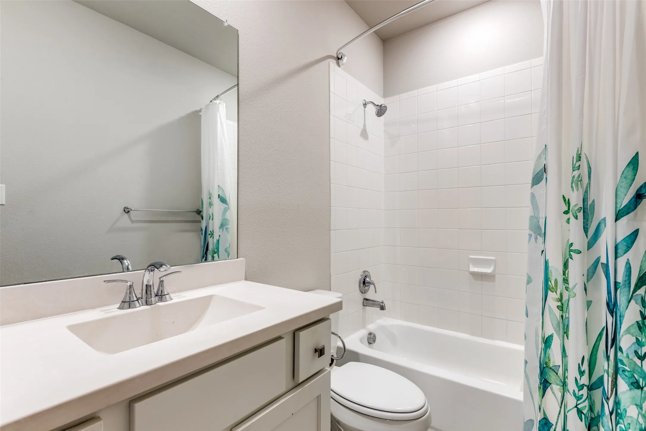 Full bathroom with shower / tub combo with curtain, vanity, and a textured wall