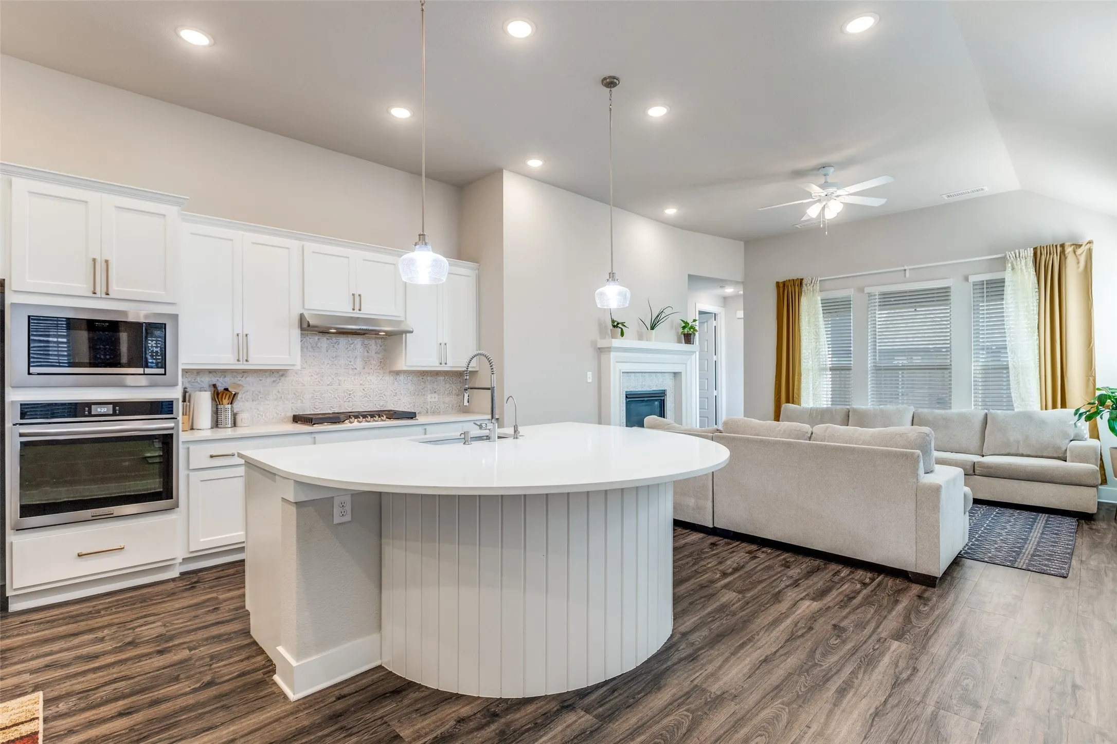 Kitchen with white cabinets, open floor plan, appliances with stainless steel finishes, decorative backsplash, and recessed lighting