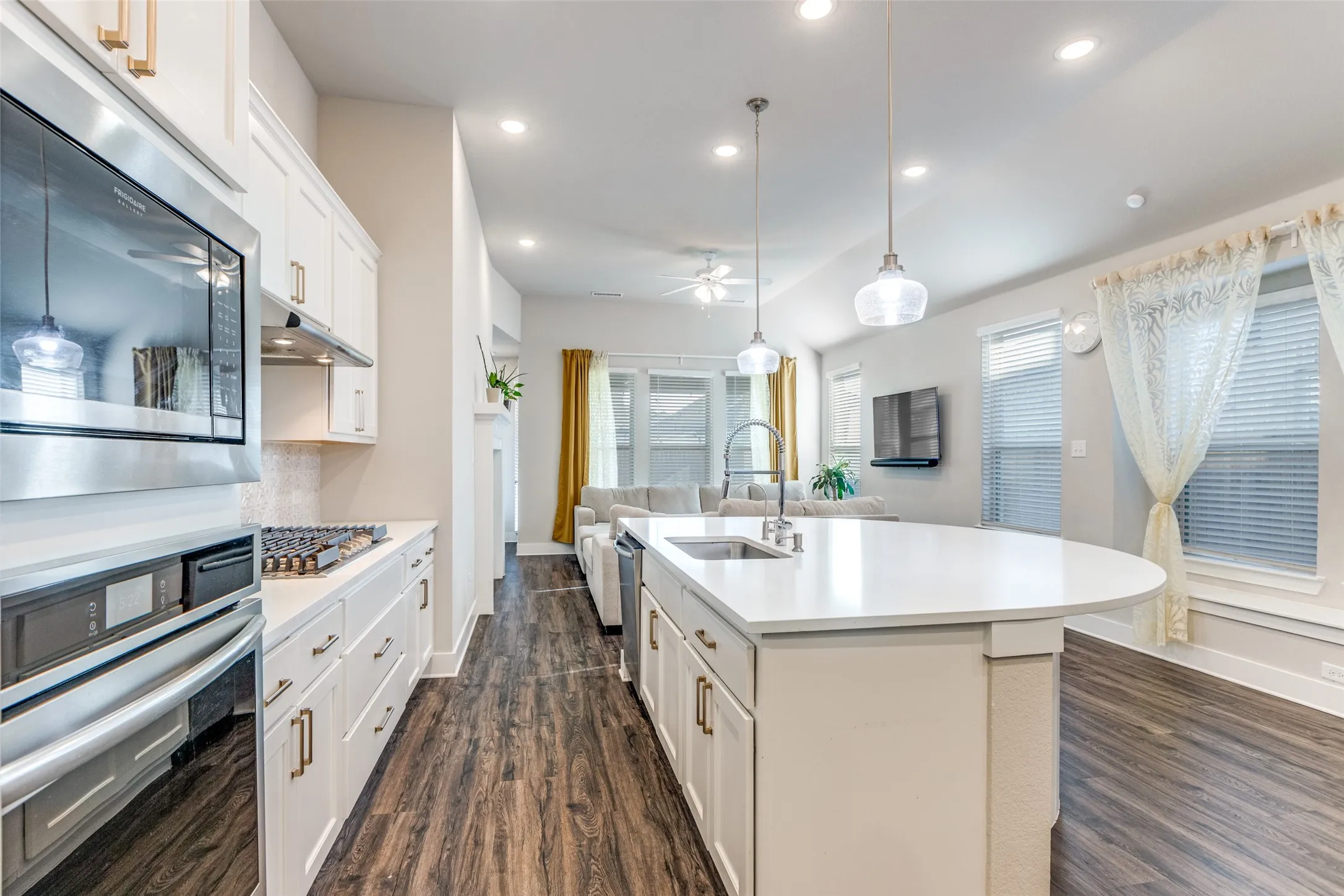 Kitchen featuring stainless steel appliances, open floor plan, white cabinets, recessed lighting, and dark wood-style floors