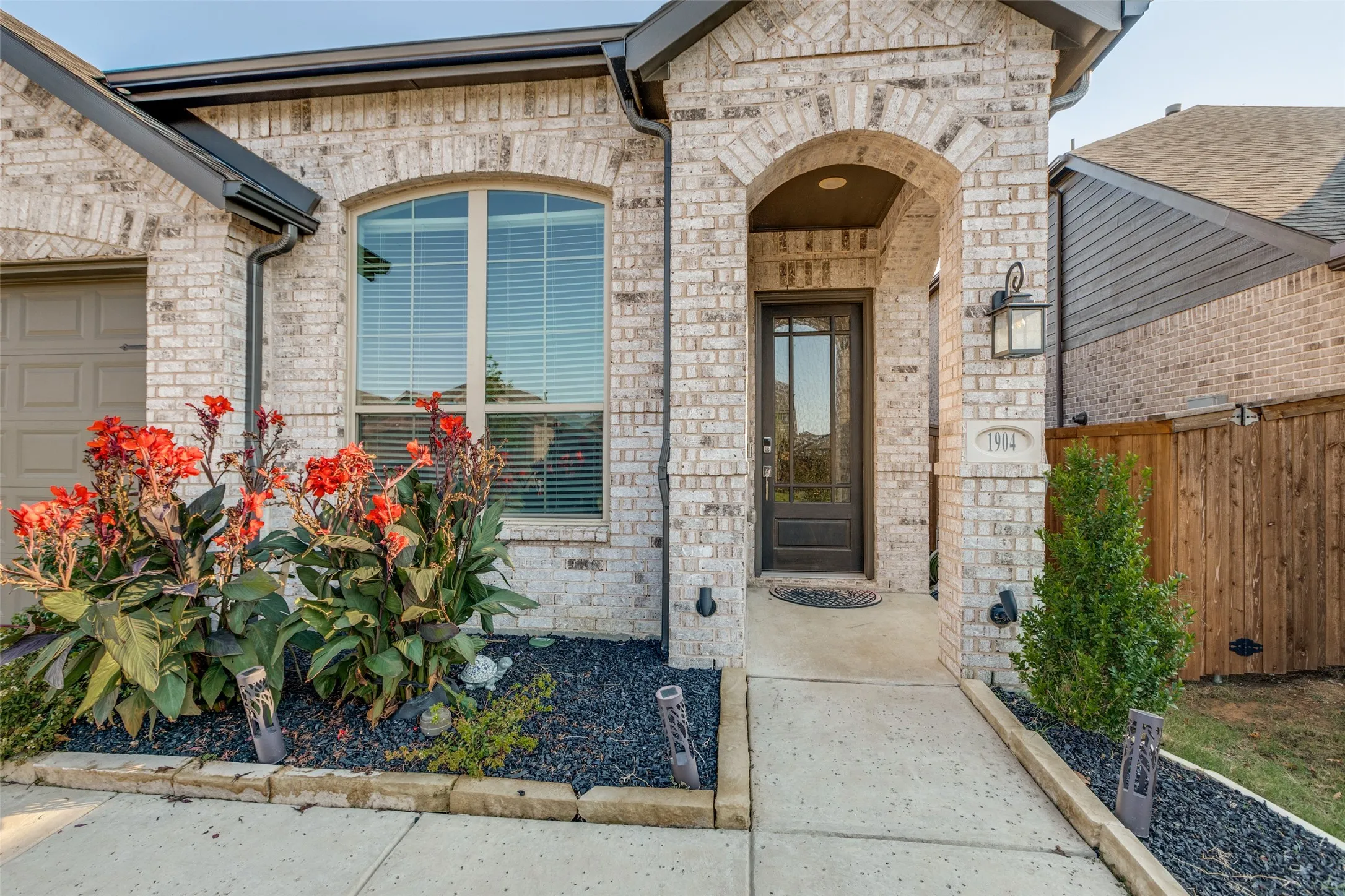 View of exterior entry with brick siding and a garage