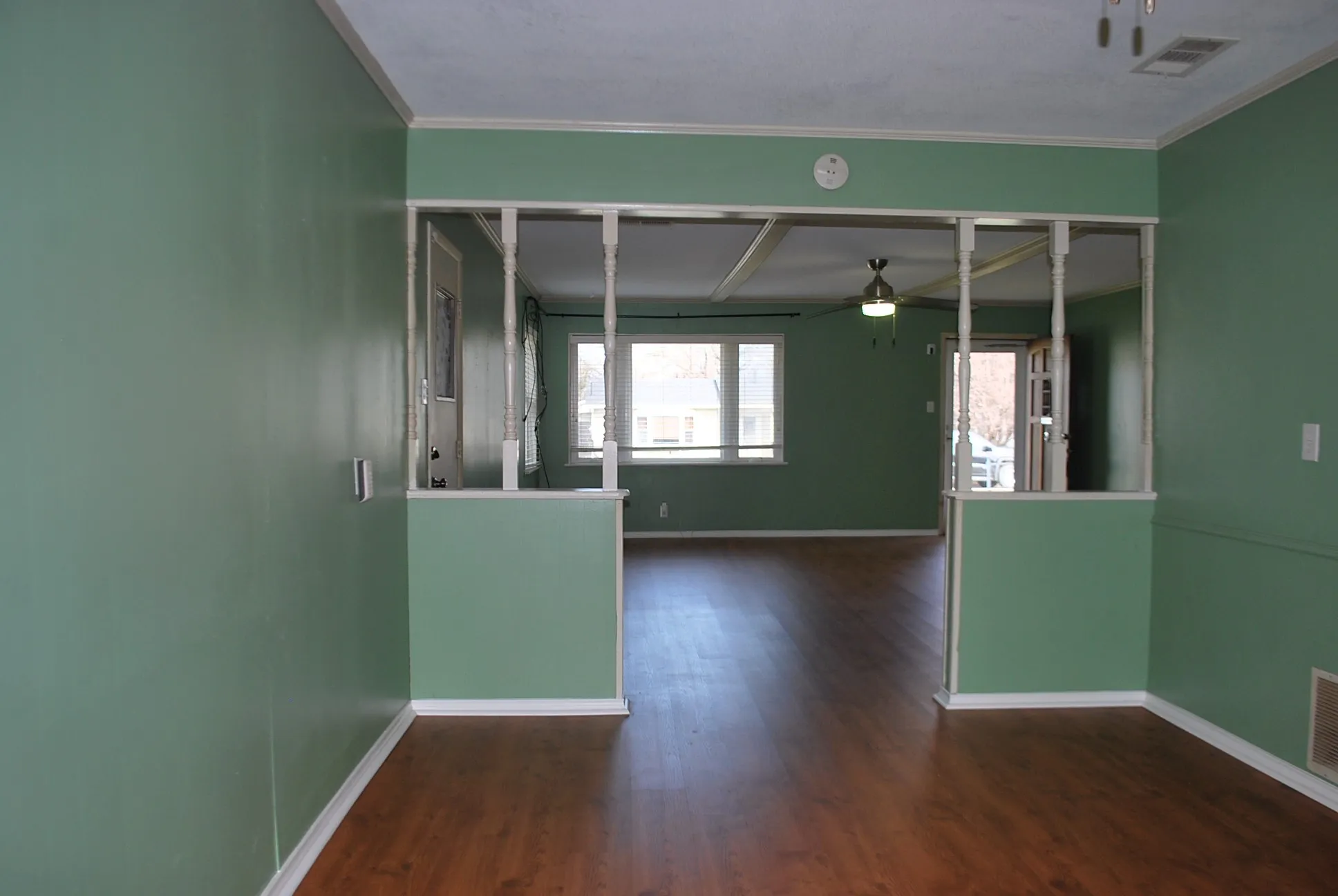 Wood-finish flooring throughout, with crisp white trim and a partial wall separation