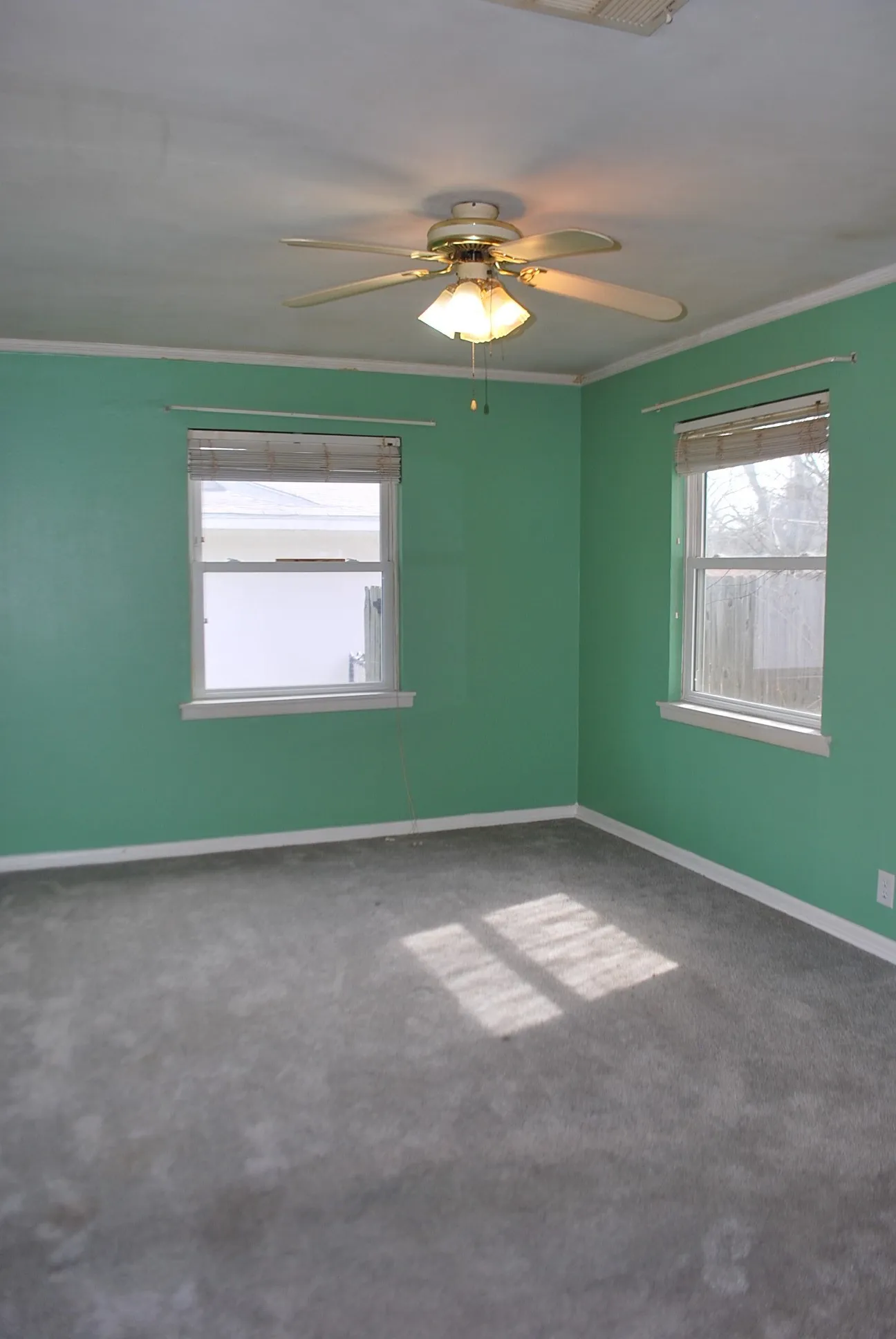 Recessed lighting, ceiling fan light fixture, two windows with blinds, wall-to-wall carpeting, and crown molding