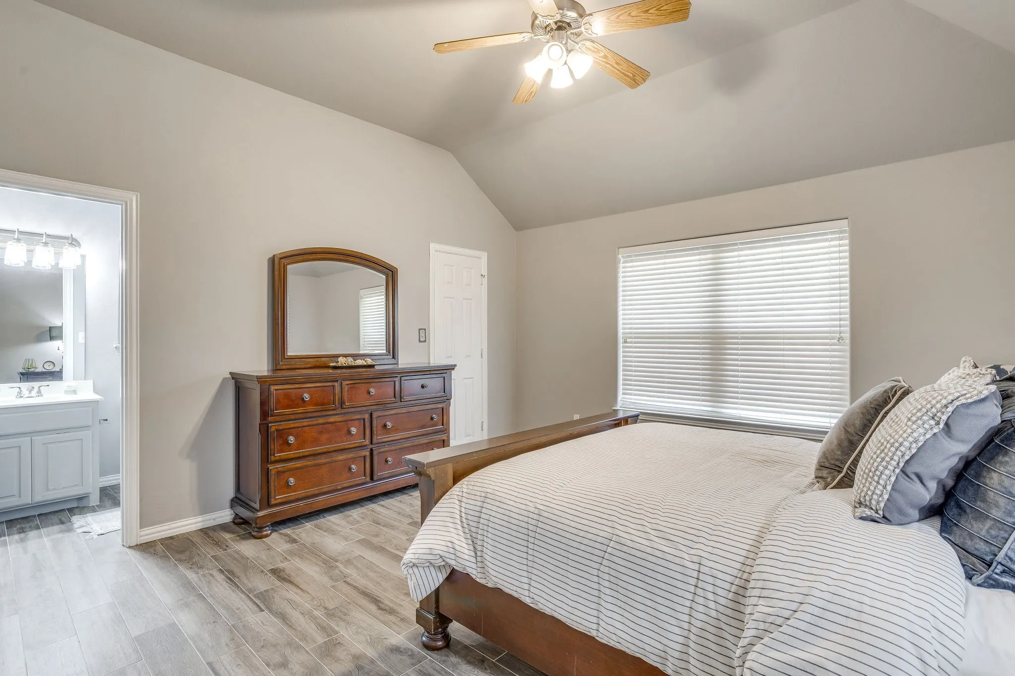 Bedroom 2 with Vaulted ceiling, a ceiling fan, wood-finish flooring, and a window with blinds