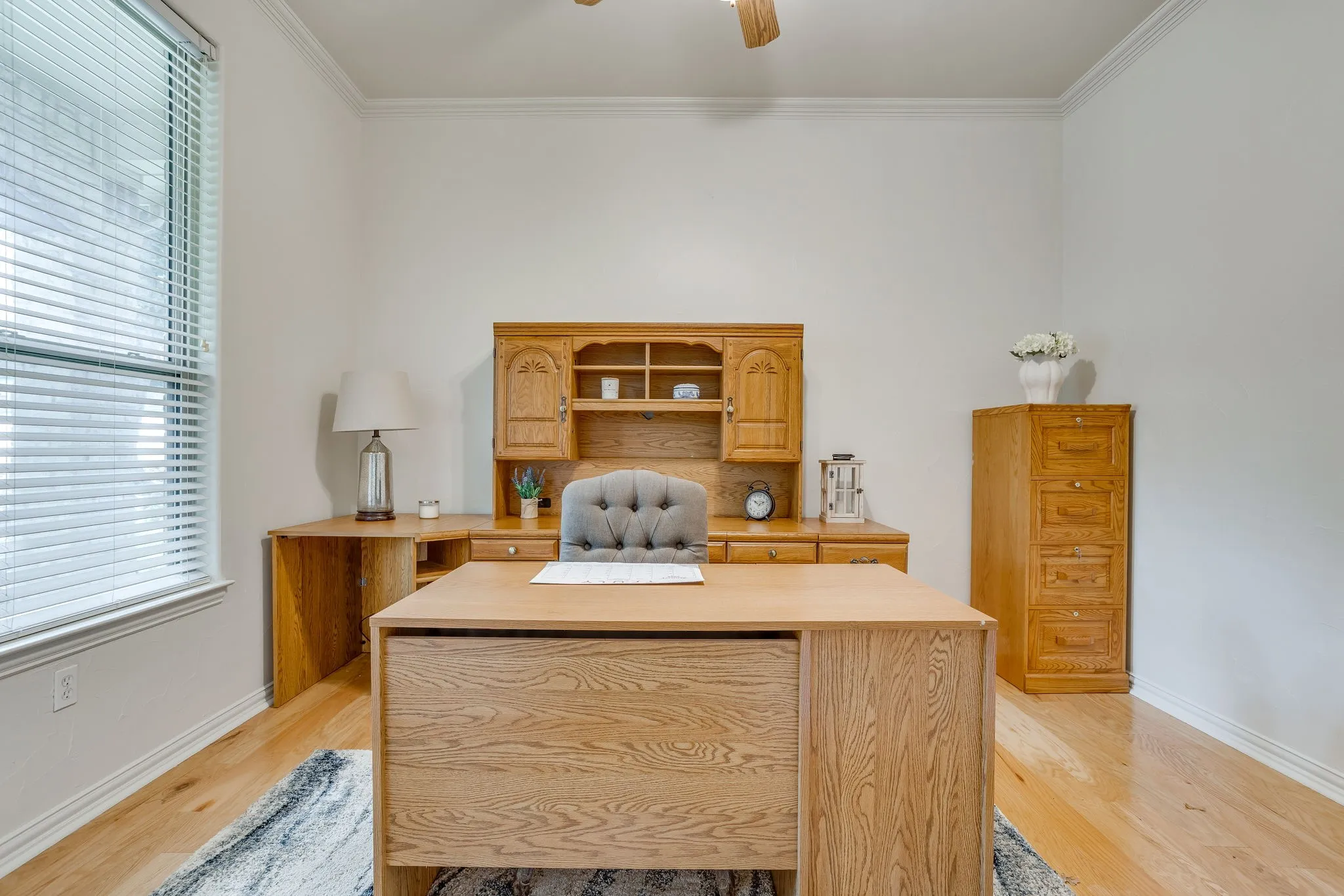 5th bedroom or office with closet with Light wood-finish flooring, crown molding, and a ceiling fan