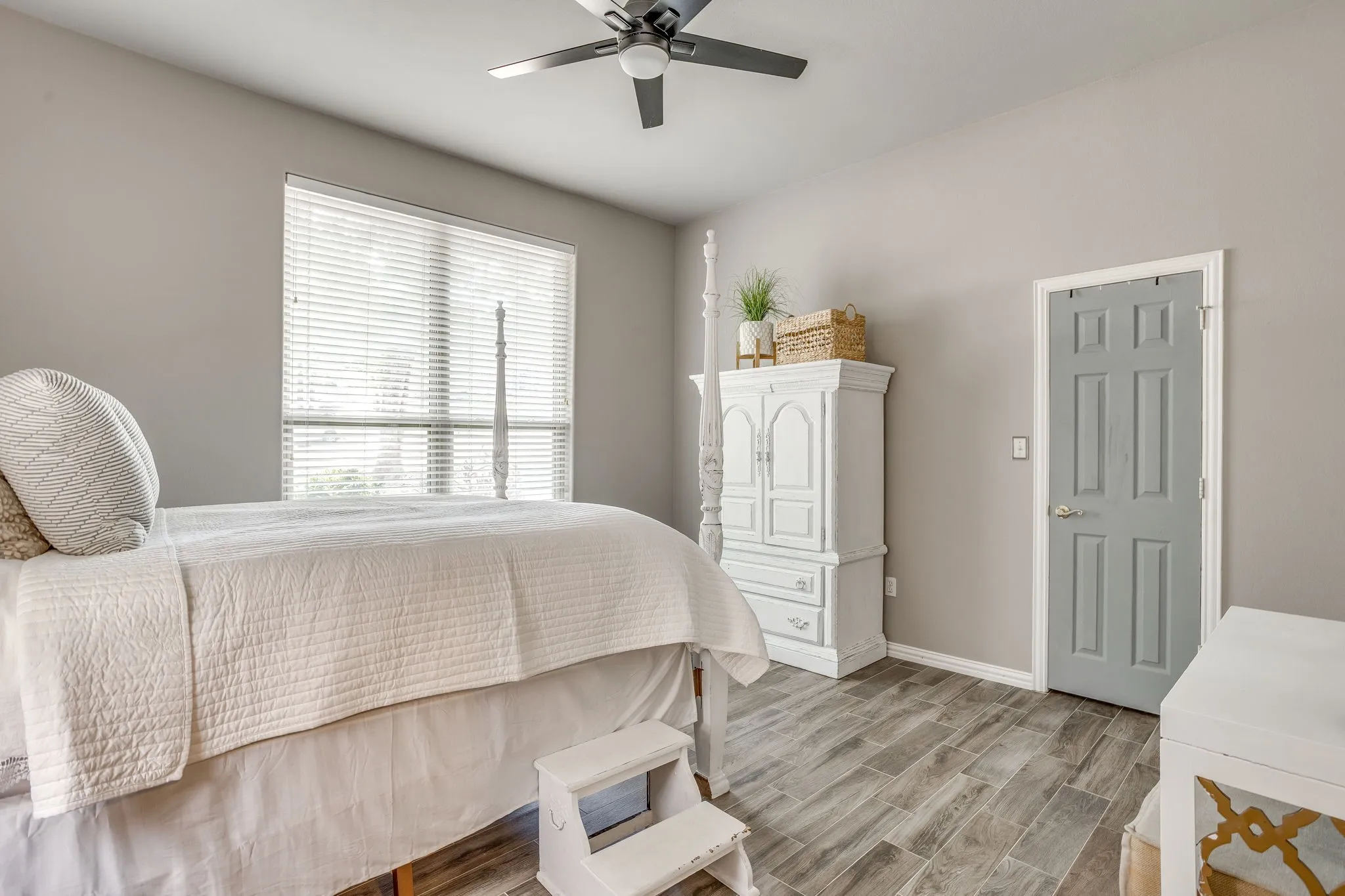 Bedroom 4 with Wood-look tile flooring, ceiling fan, paneled interior door, and large window with blinds