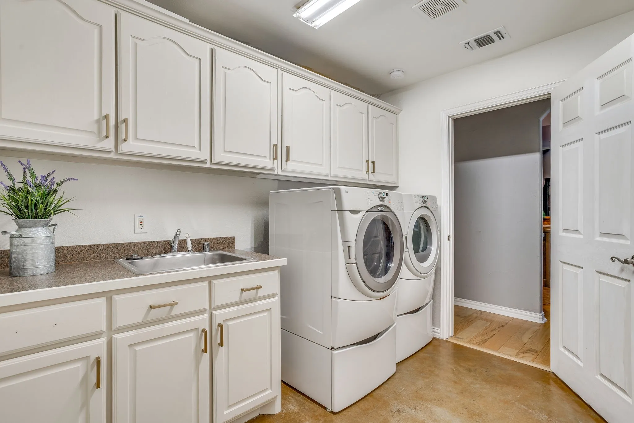 Utility space with light cabinetry, a utility sink, and a countertop