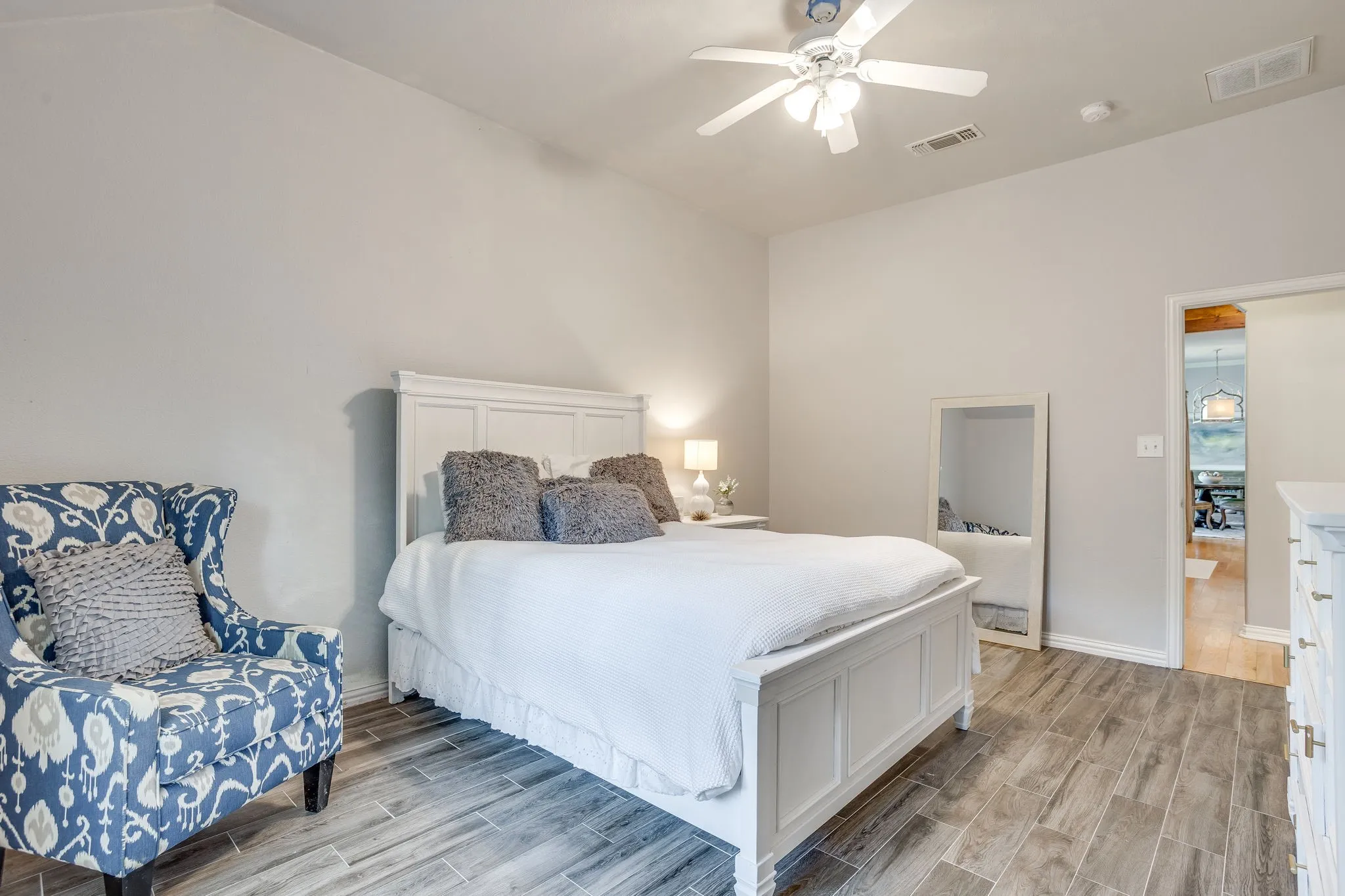 Bedroom 3 with Vaulted ceiling with a ceiling fan, light gray wall paint, wood-finish flooring, and white trim