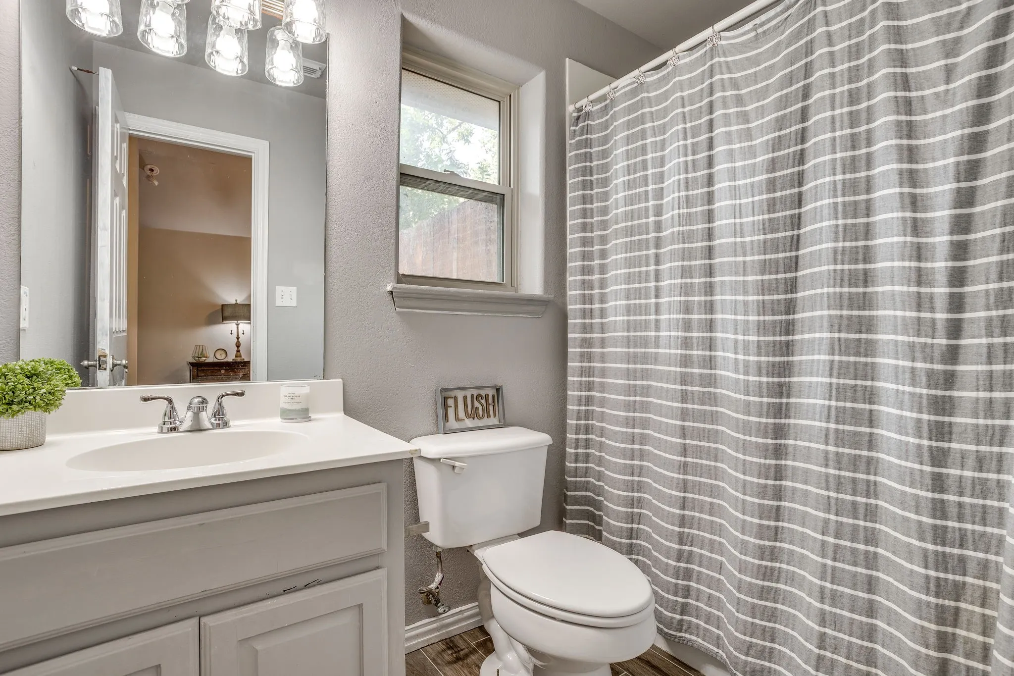 Private ensuite with Vanity with a white countertop and integrated sink, chrome faucet, and overhead light fixture