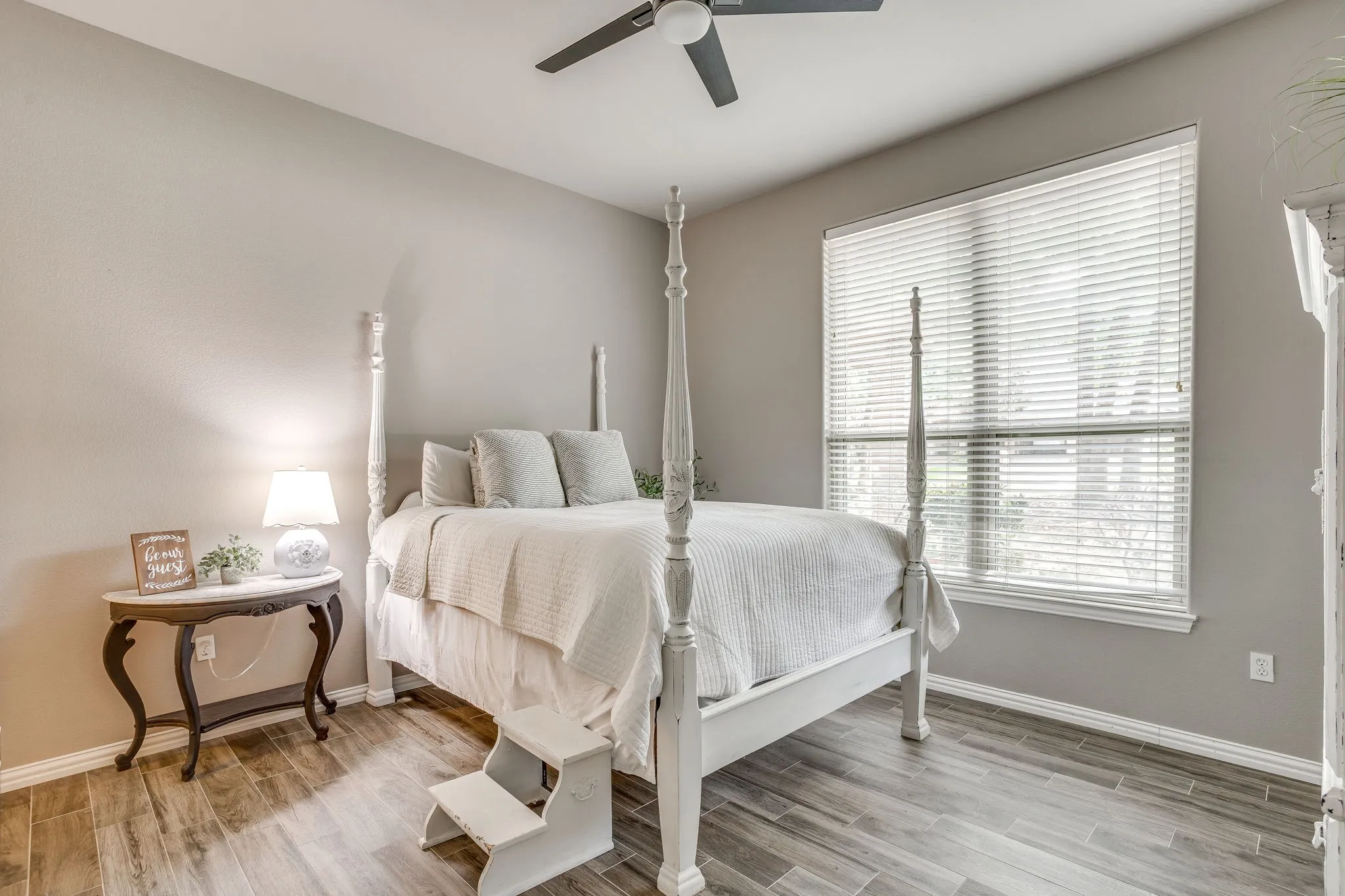 Bedroom 4 with Wood-finish flooring with a neutral paint palette, a window with horizontal blinds, and a ceiling fan
