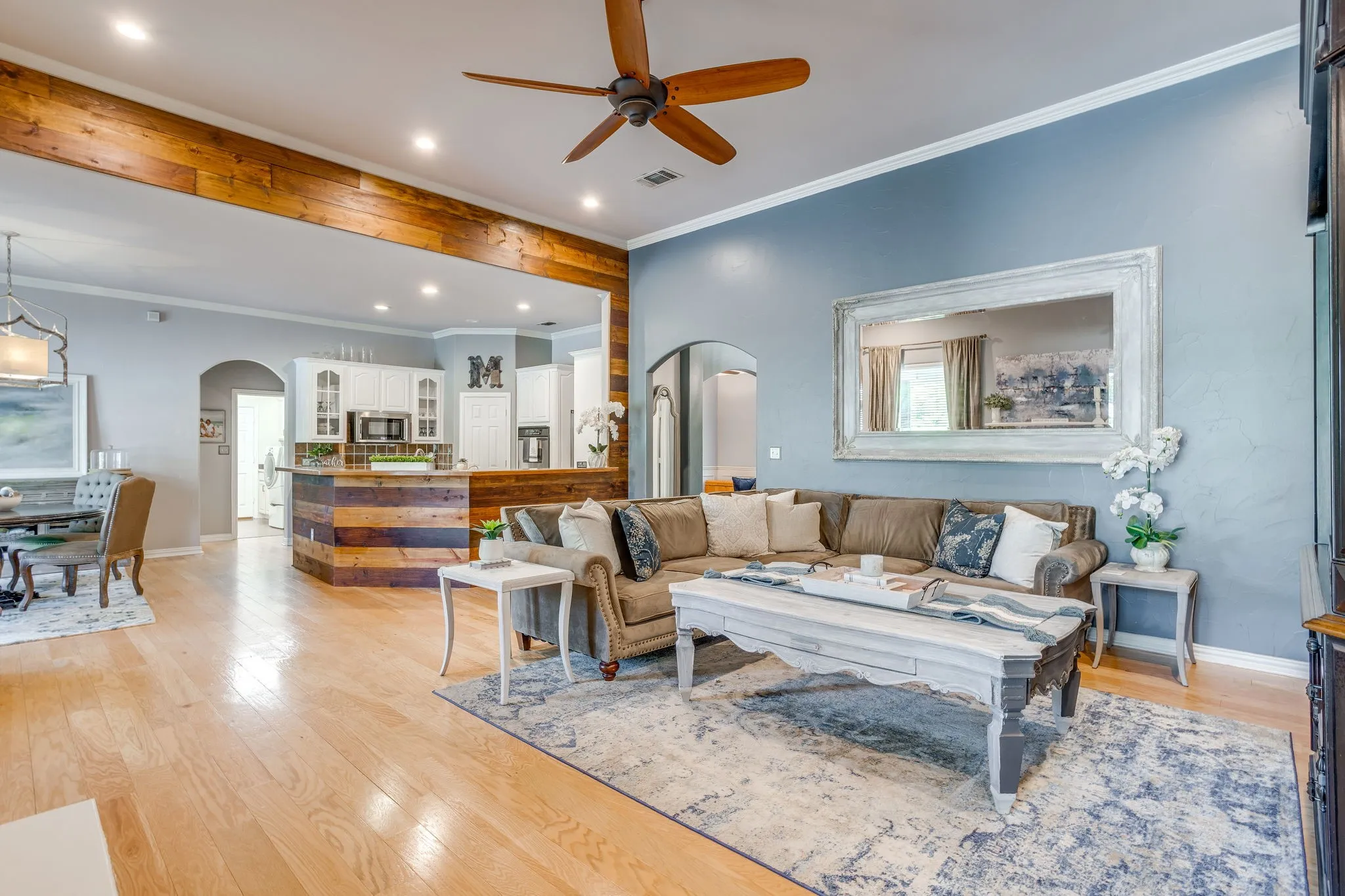 Wood-finish flooring throughout, recessed lighting, ceiling fan, and wood-wrapped architectural beam