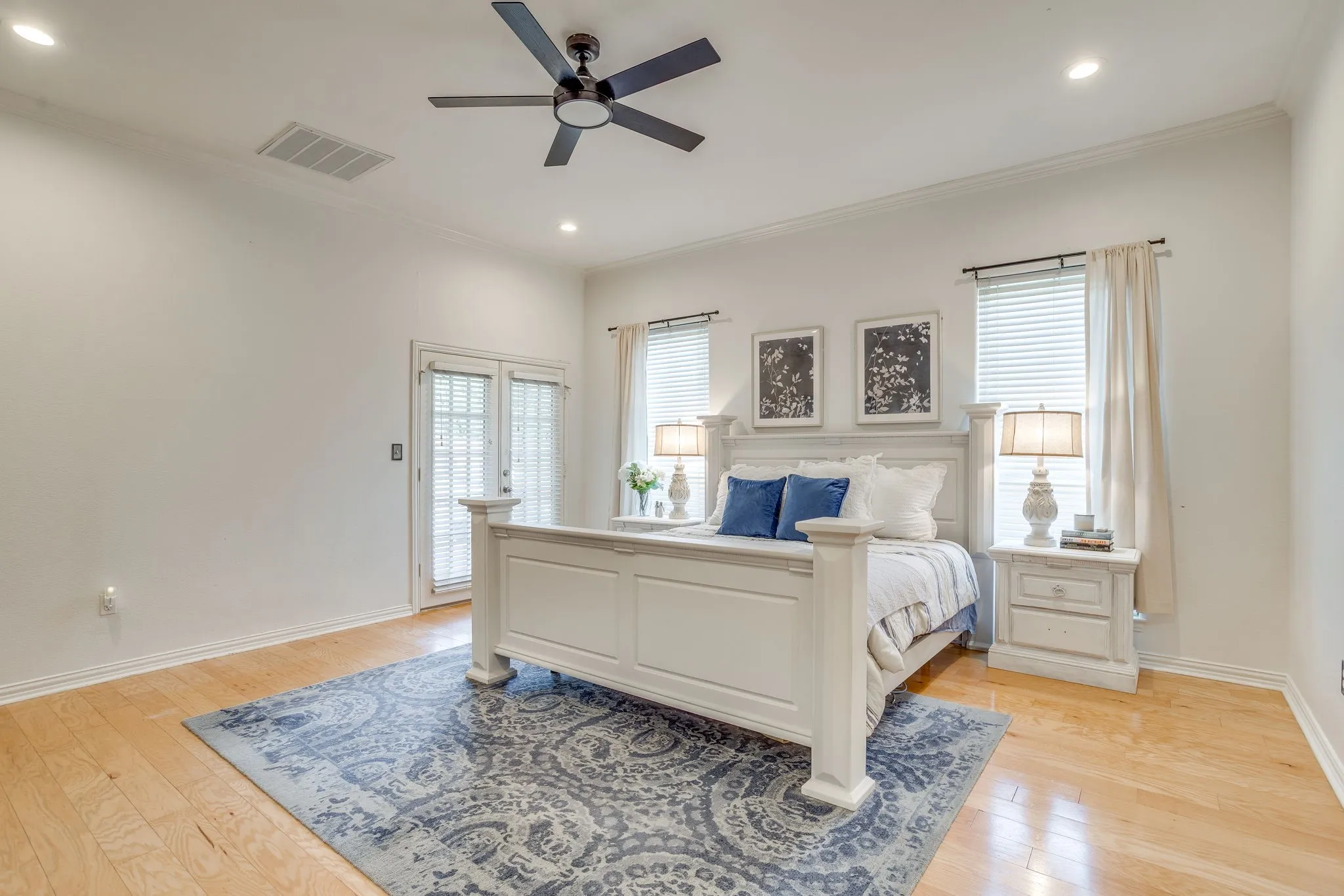 Primary Bedroom with Hardwood flooring, recessed lighting, ceiling fan, and French doors