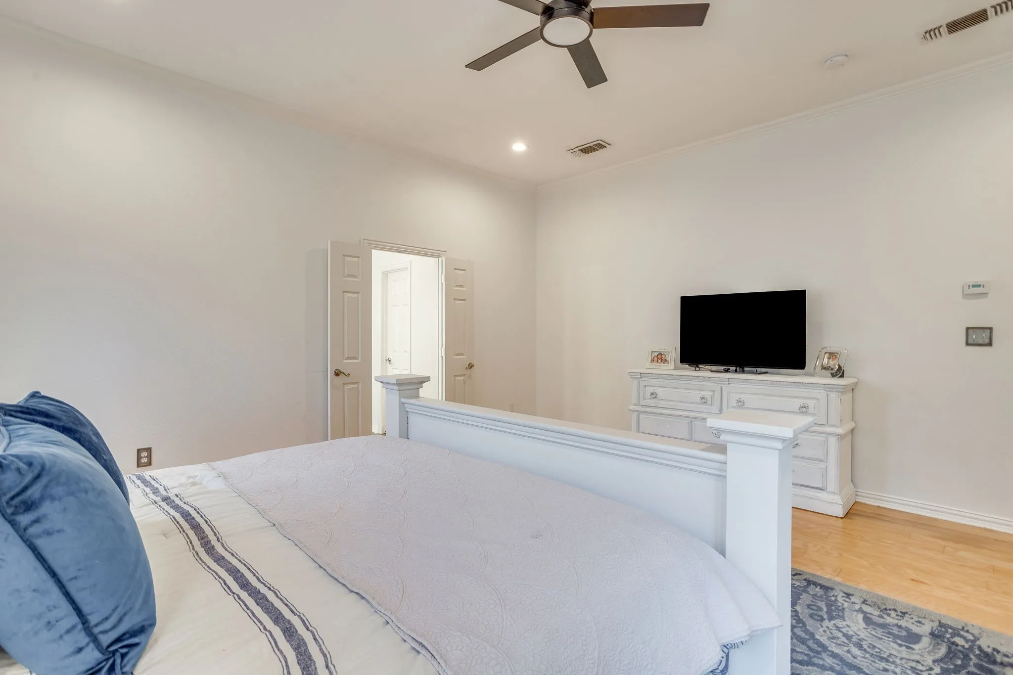 Primary Bedroom with Hardwood flooring with a ceiling fan, recessed lighting, and a double-door entry