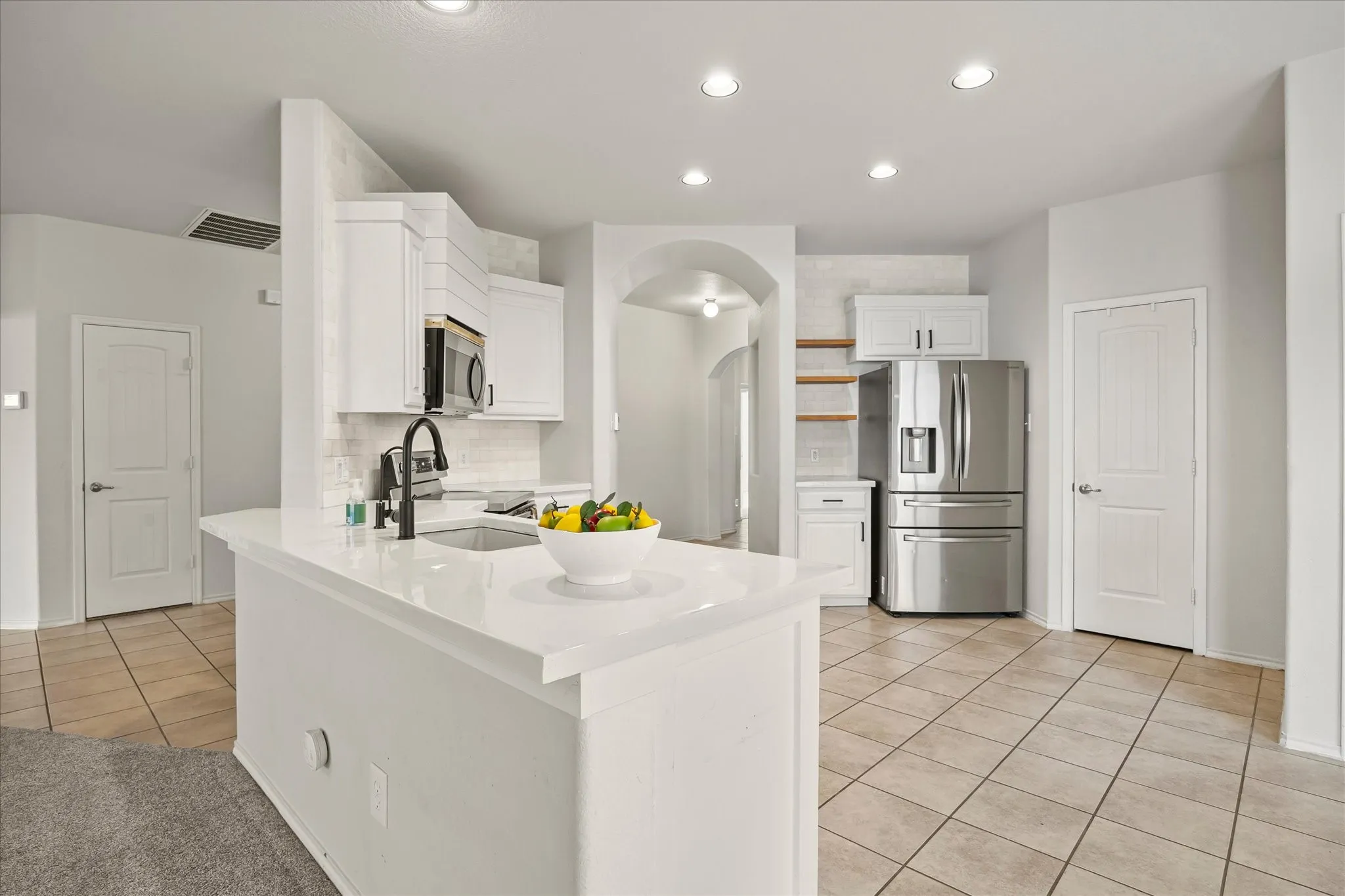 Kitchen island, stainless steel appliances and walk in pantry