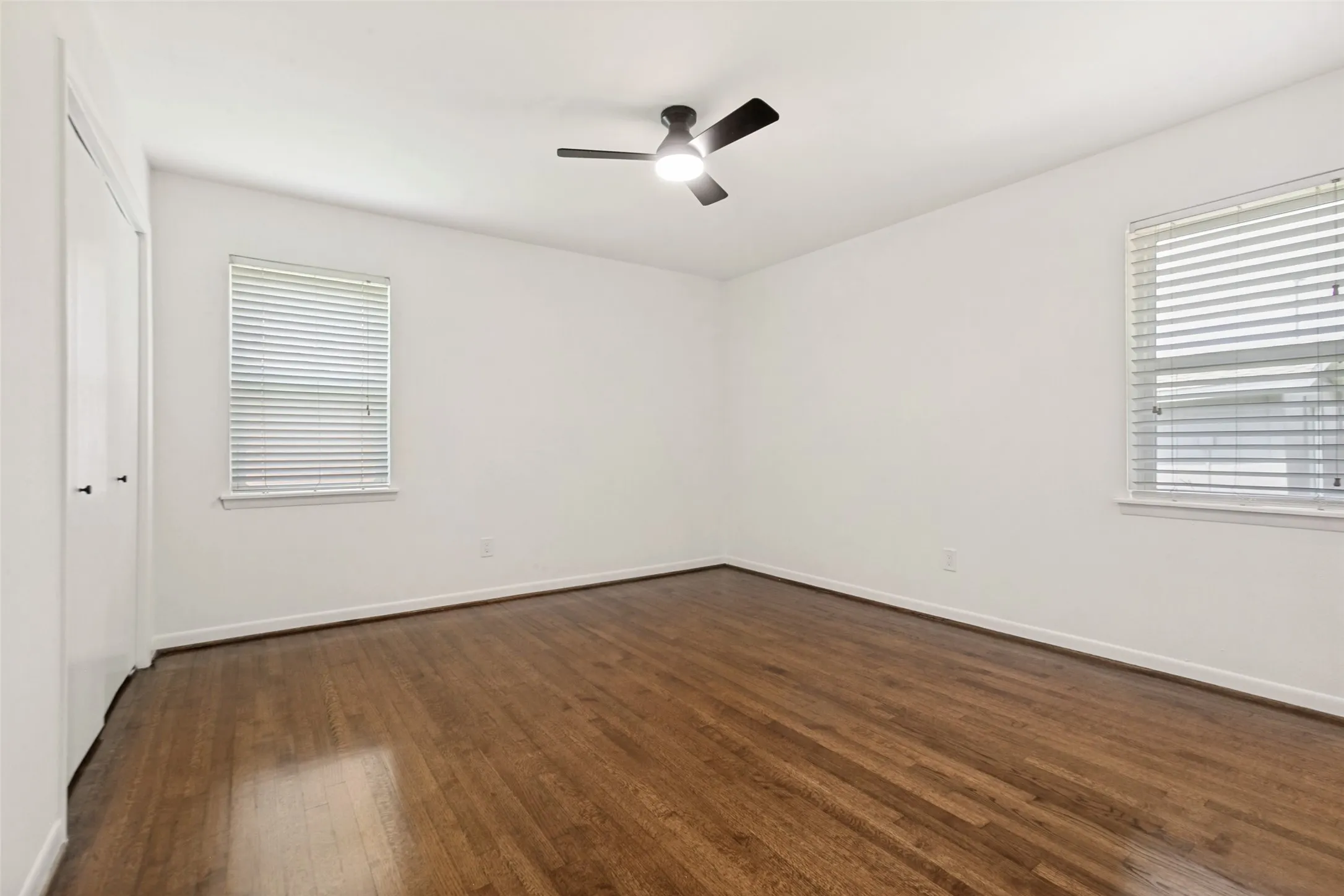 Primary bedroom with ceiling fan, closet and ensuite bathroom