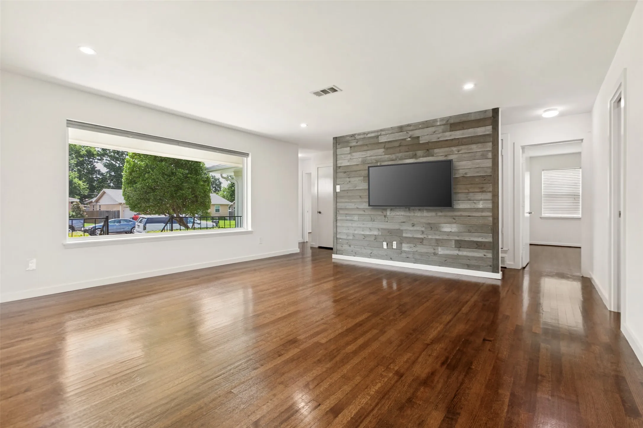 Living Room with views of the front yard and hallway leading to all 3 bedrooms