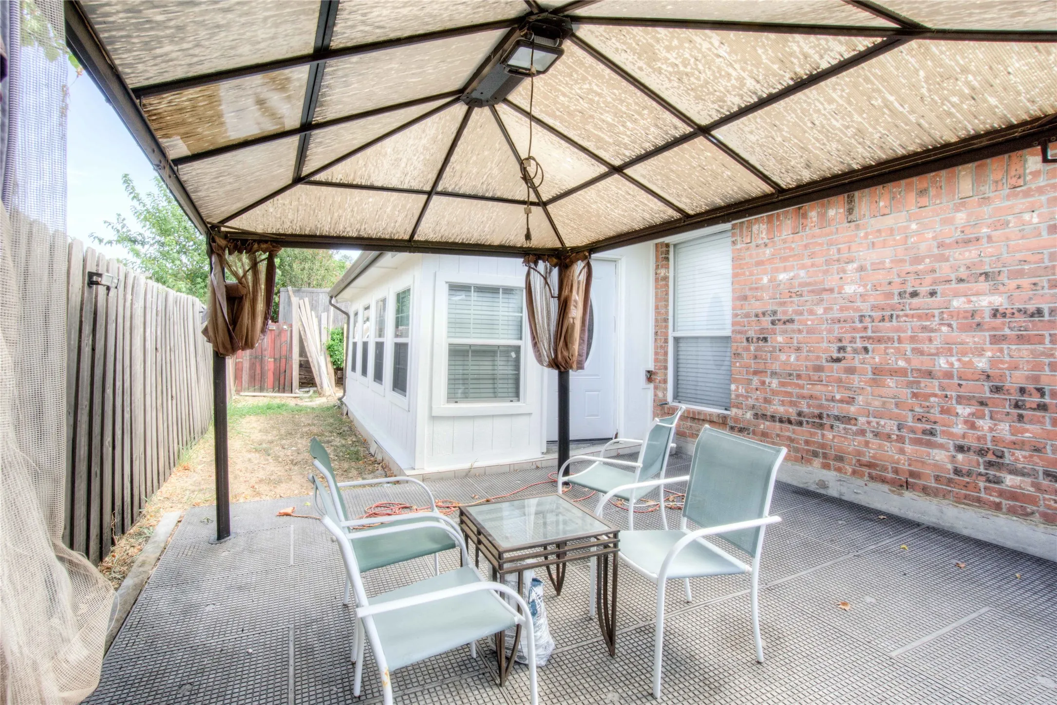 Covered outdoor patio with a metal gazebo structure and a textured canopy